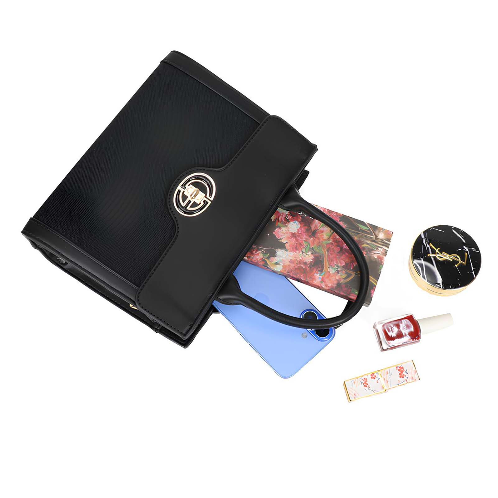 Bolso negro con la parte superior abierta, revelando teléfono, revista, maquillaje y esmalte de uñas.