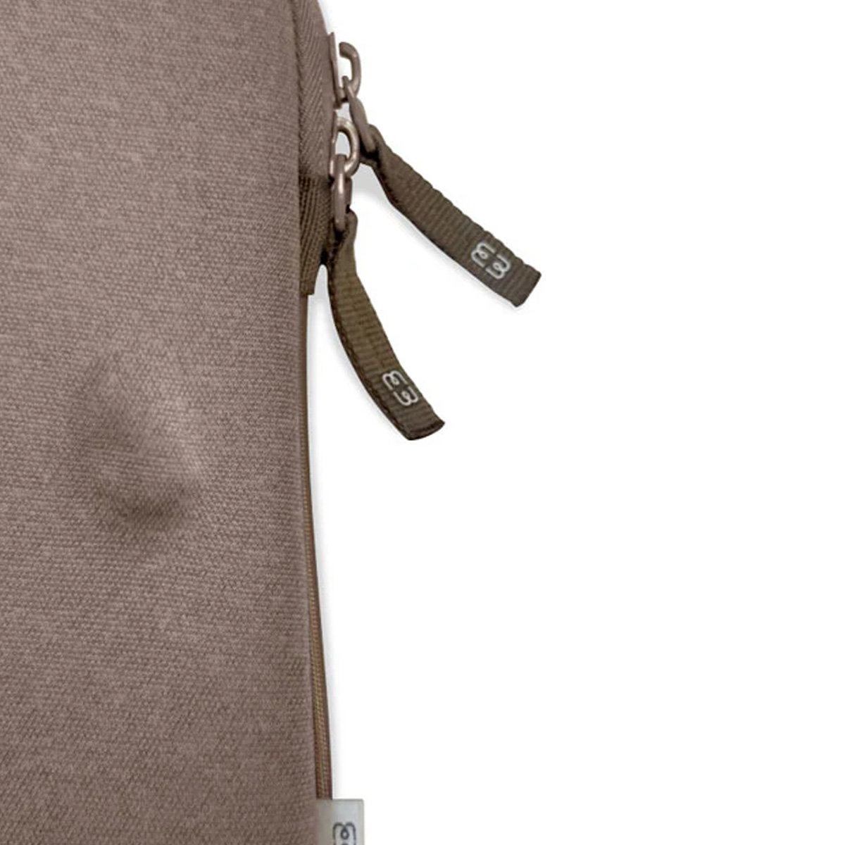Primo piano di una borsa marrone con cerniera. Due cinghie verde oliva con etichette 'E3' pendono. Sfondo bianco.