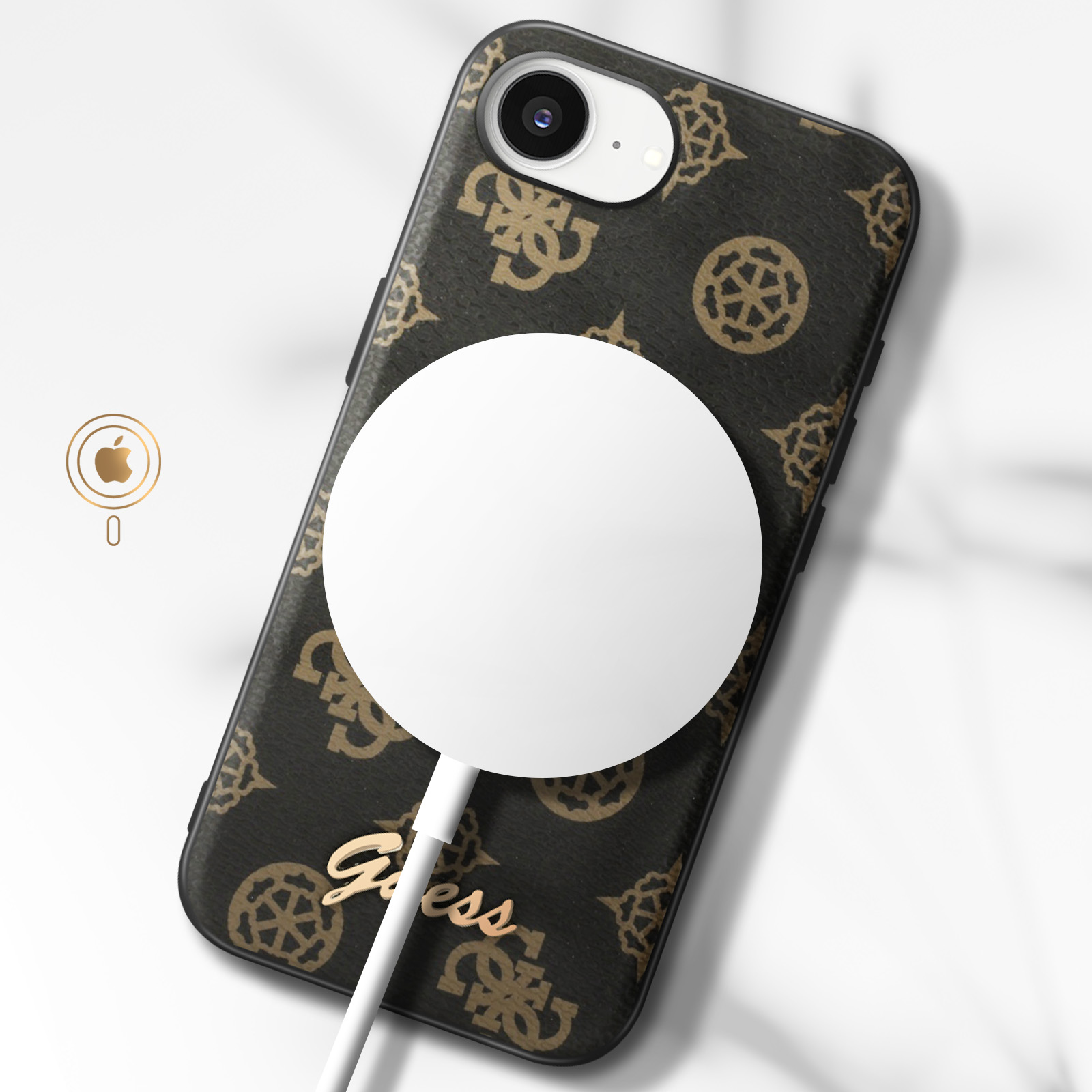 Un téléphone dans un étui Guess avec un chargeur sans fil. L'étui est marron à motifs, le chargeur blanc.