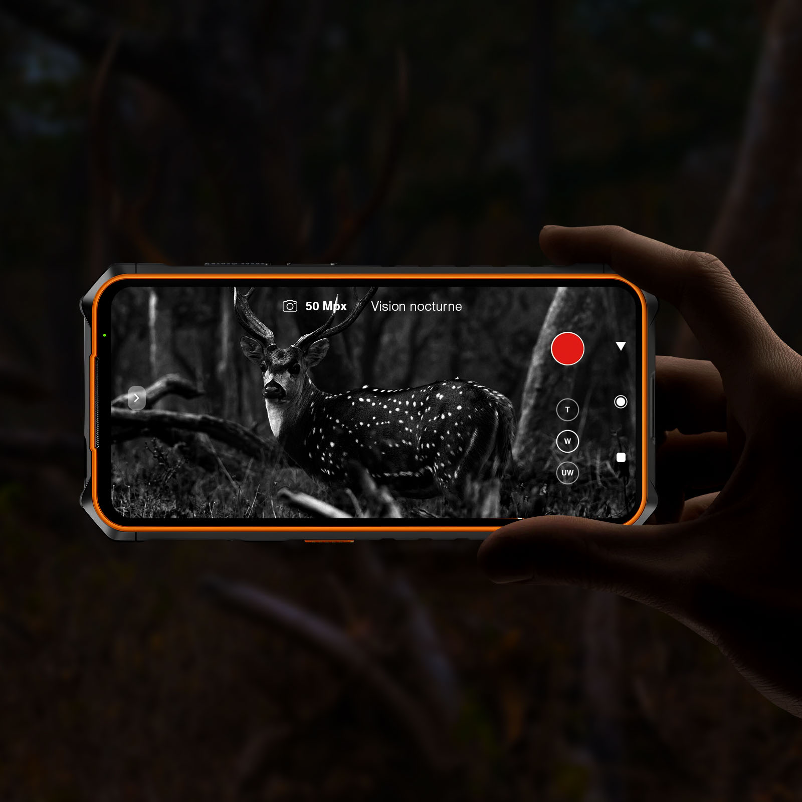 Eine Hand hält ein Telefon, das ein Reh zeigt. Der Bildschirm zeigt ein Schwarzweißbild mit dem Text 'Vision nocturne'.