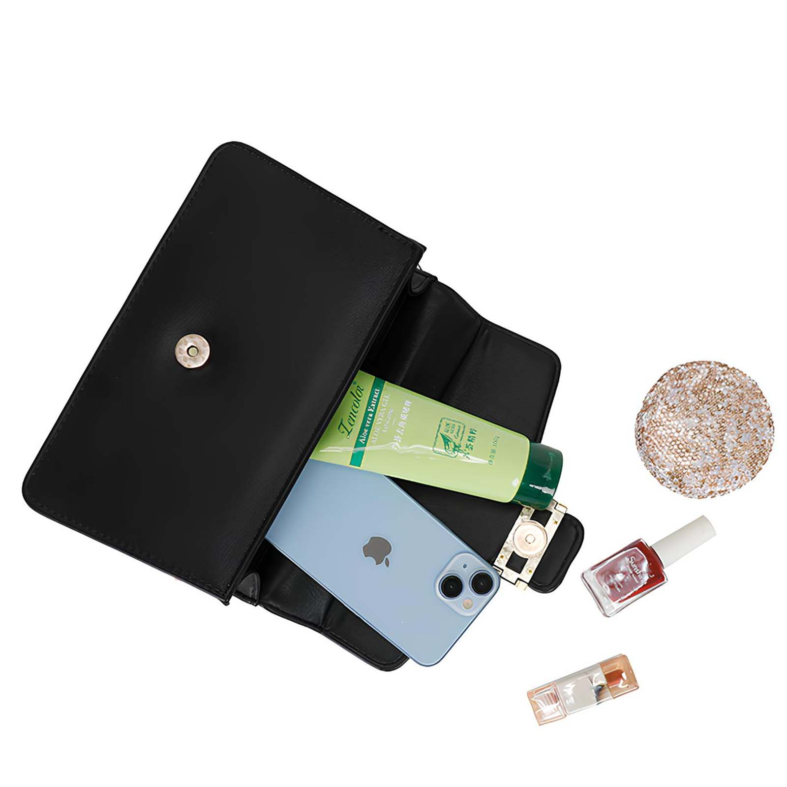 Bolso negro con teléfono, loción, maquillaje y una bola decorativa. Los artículos se caen del bolso.