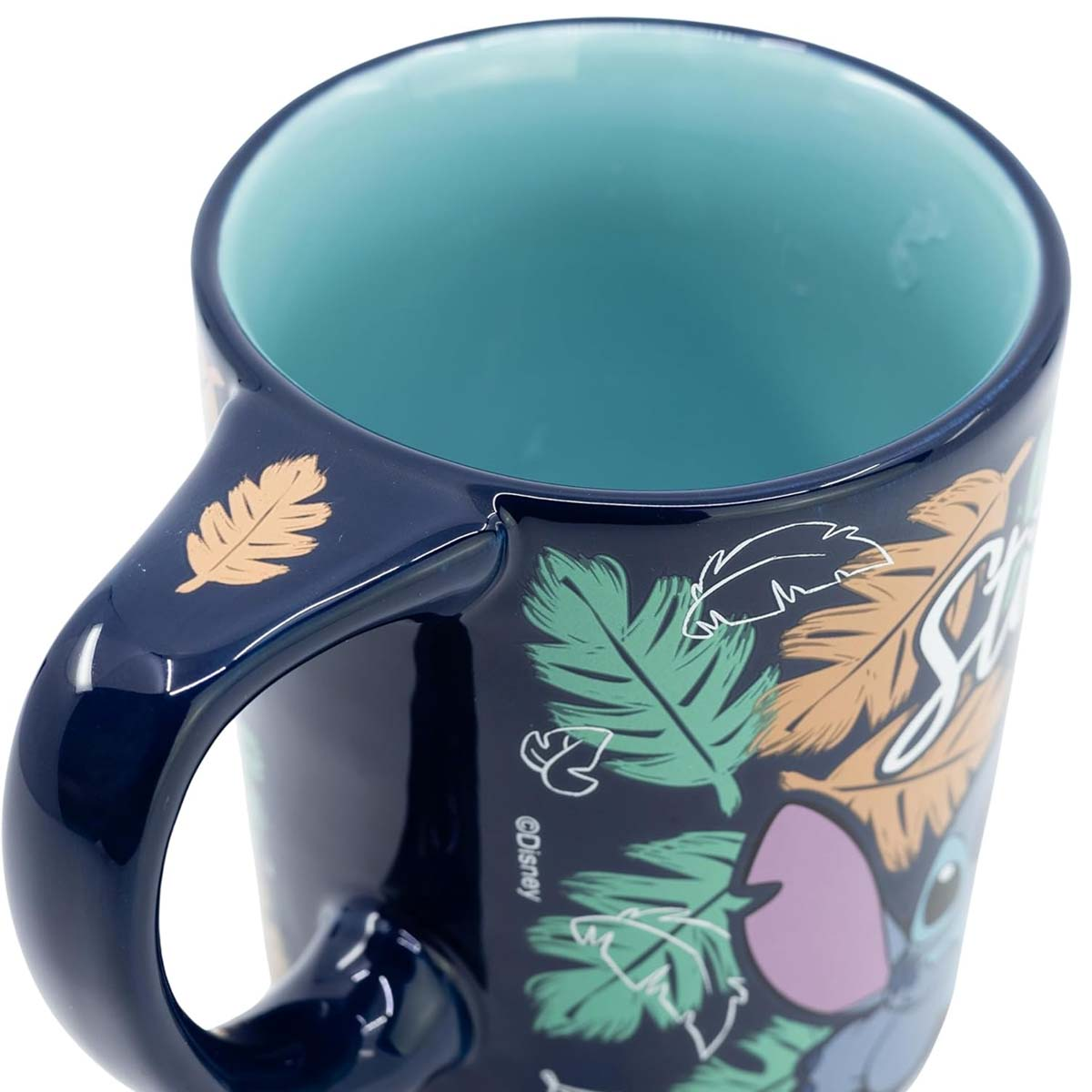 Dunkelblauer Becher mit Stitch-Design, grünen und braunen Blättermustern und blaugrünem Innenraum. Griff links.