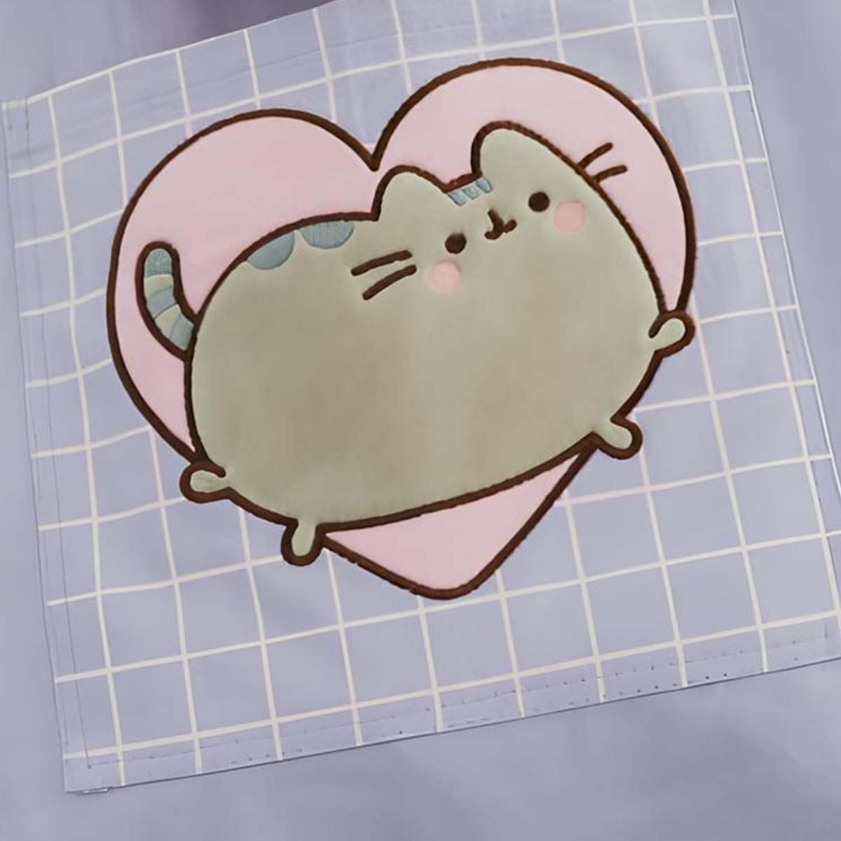Un gatto dei cartoni animati con un cuore rosa su sfondo a griglia. Il gatto è grigio con guance rosa e coda a strisce.