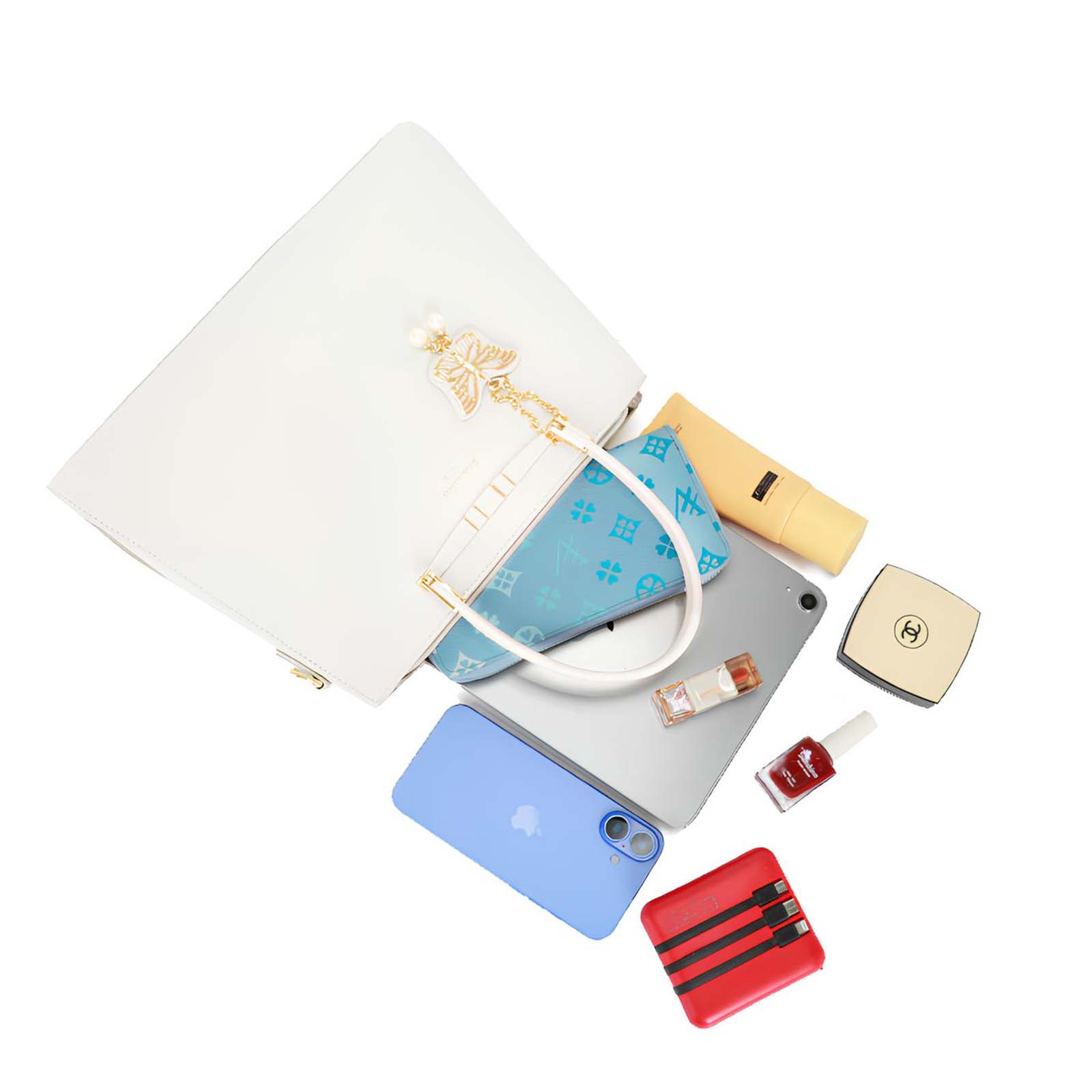 Bolso blanco con charm de mariposa, bolsa azul, teléfono, iPad, maquillaje, esmalte de uñas y power bank rojo sobre blanco.