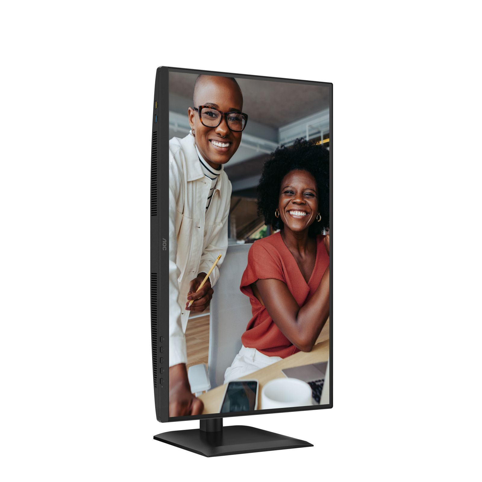 Twee lachende vrouwen op een monitor. Een houdt een potlood vast, de ander zit aan een bureau. Monitor is zwart, tegen een witte achtergrond.