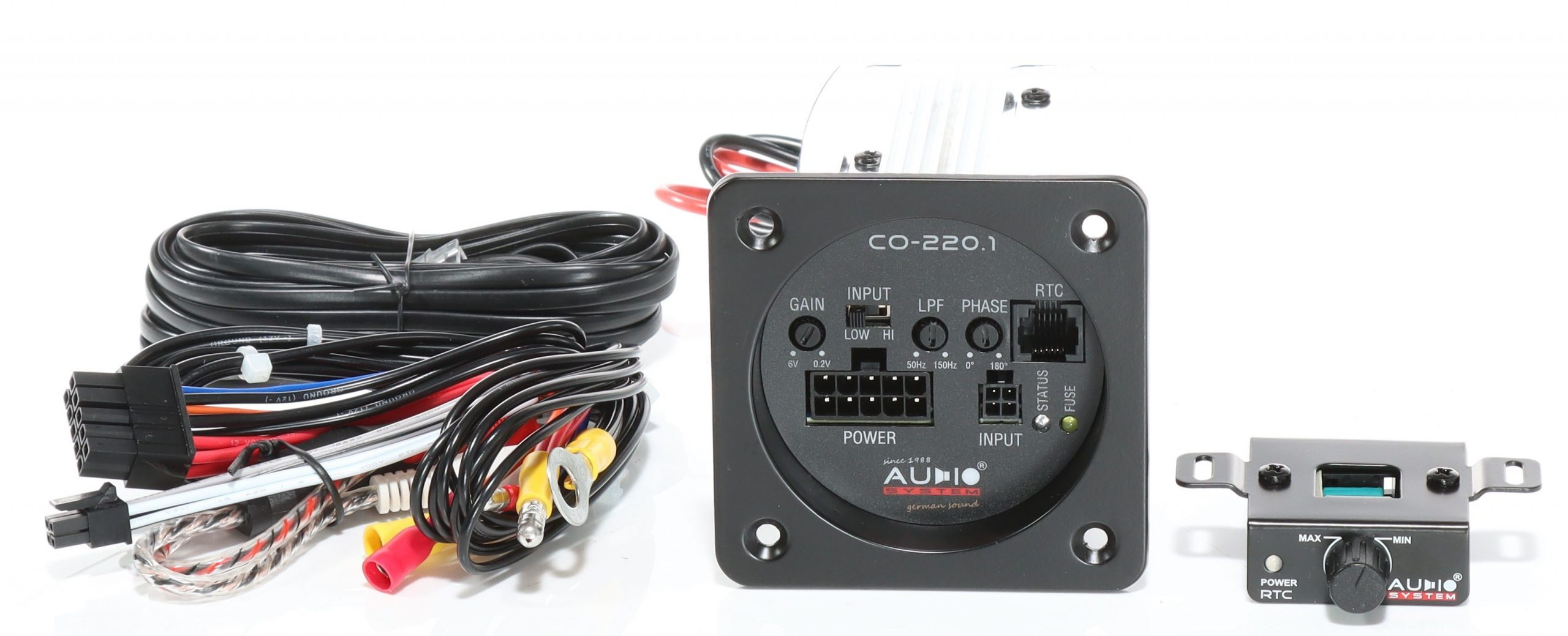 Ein Auto-Audiosystem mit schwarzer Steuereinheit, Kabeln und einer kleinen Fernbedienung. Schwarze, rote und gelbe Drähte sind sichtbar.