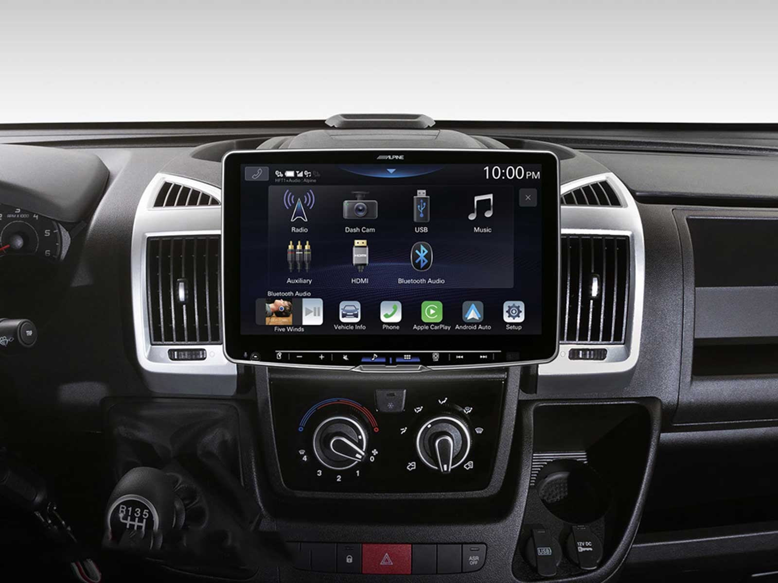 Aut Armaturenbrett mit Touchscreen, der Radio, USB und andere Optionen anzeigt. Bedienelemente und Schalthebel sind sichtbar.