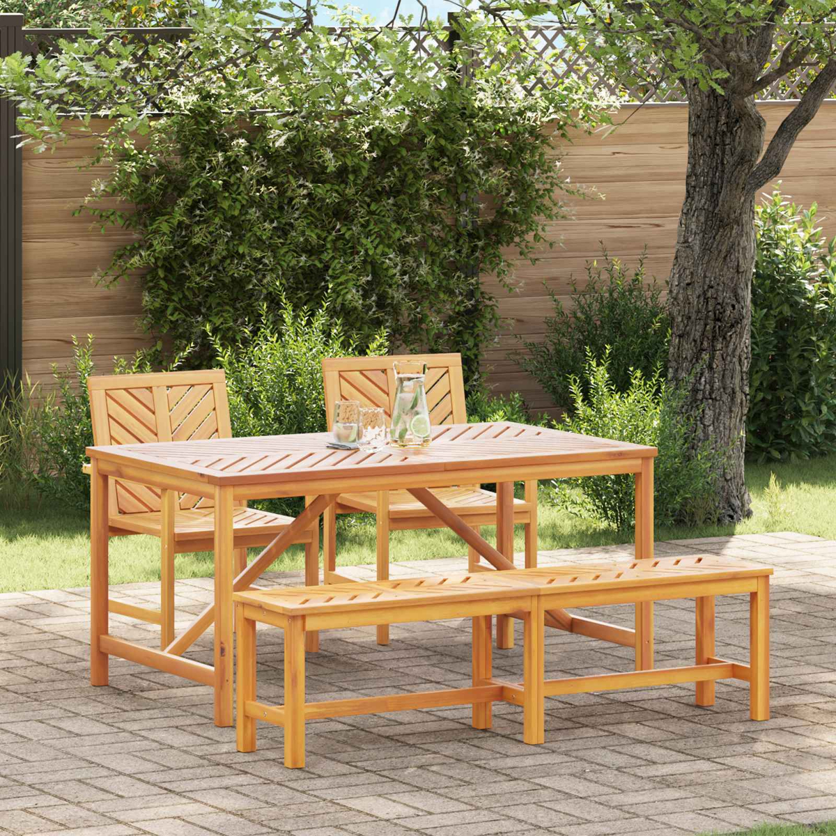 Essgruppe aus Holz im Freien mit Tisch, zwei Stühlen und einer Bank. Im Hintergrund ist ein grüner Garten mit Holzzaun zu sehen.