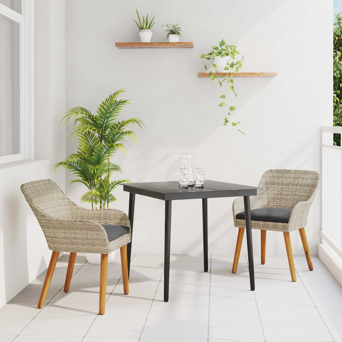 Balkonszene mit Tisch, zwei Stühlen und Pflanzen. Der Tisch ist schwarz, die Stühle haben graue Kissen. Pflanzen auf Regalen und in Töpfen.