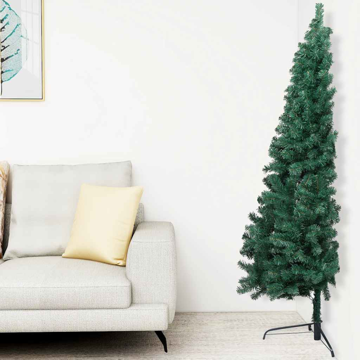 Ein grüner Weihnachtsbaum steht neben einem hellgrauen Sofa mit Kissen. Ein Gemälde hängt an der Wand.