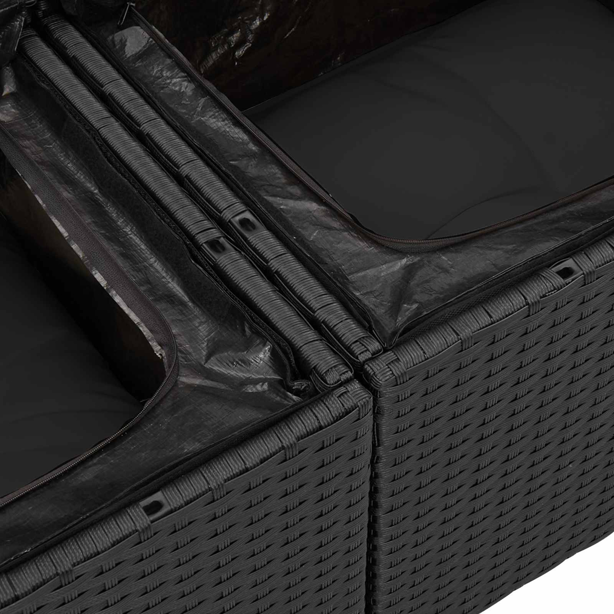 Primo piano di mobili neri intrecciati con coperture nere con cerniera. Alcune sezioni sono aperte, rivelando cuscini.