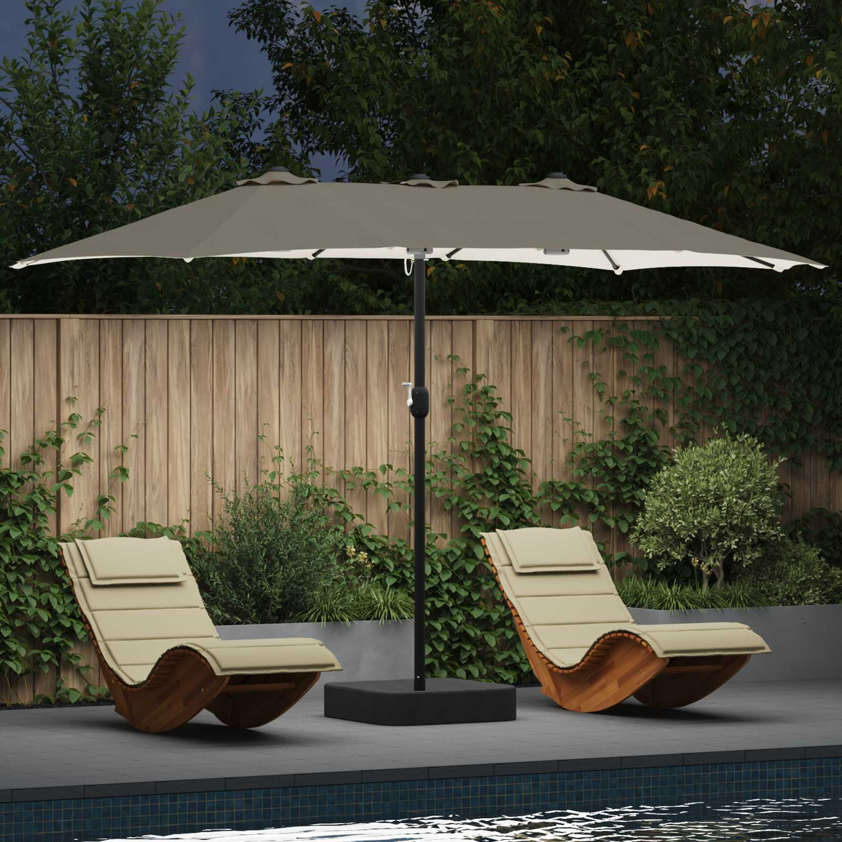 Due sedie a sdraio beige sotto un ombrello grigio. Una staccionata in legno e vegetazione dietro, piscina in primo piano.