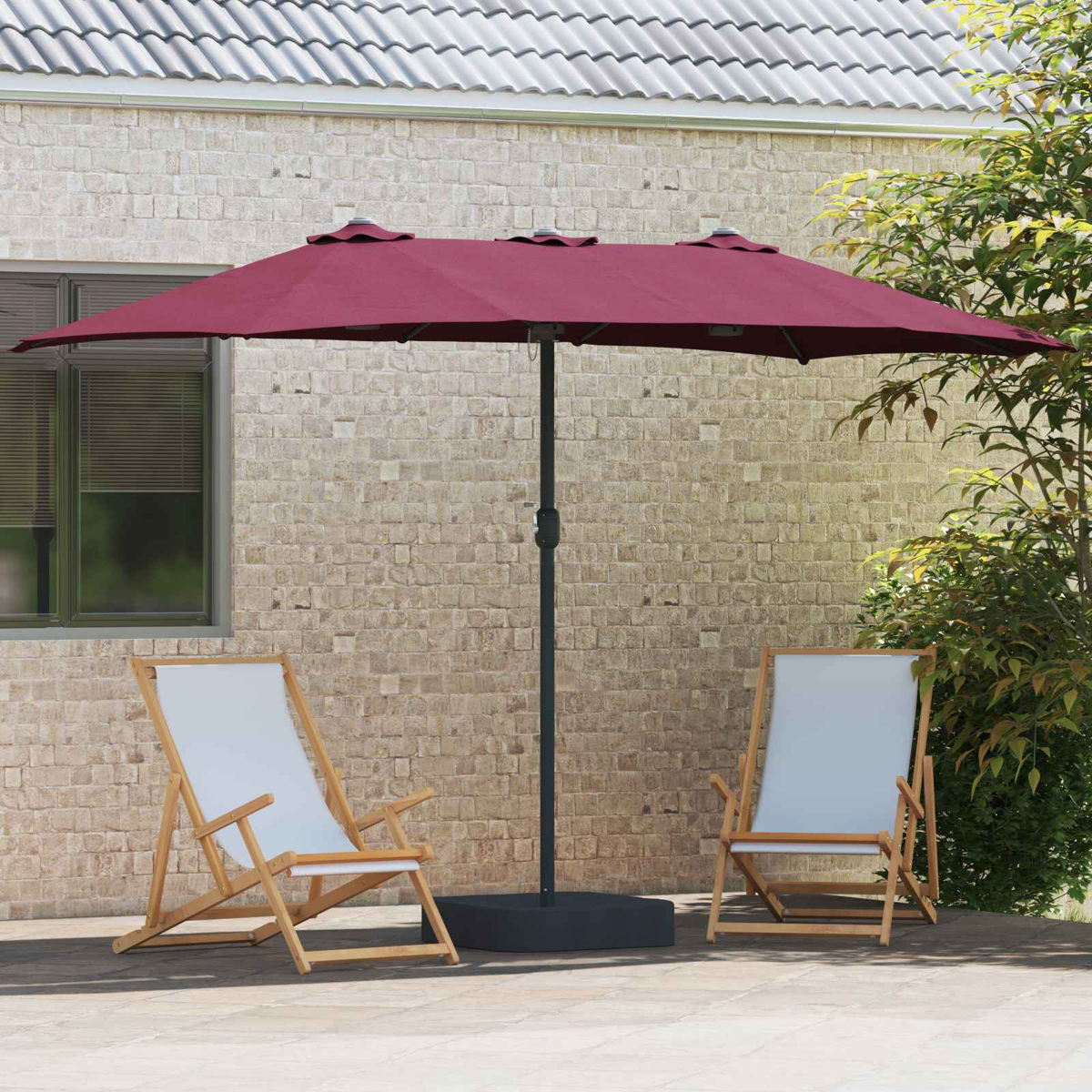 Un ombrello bordeaux ombreggia due sedie con seduta bianca. La scena è ambientata su un patio con un muro di mattoni e fogliame.
