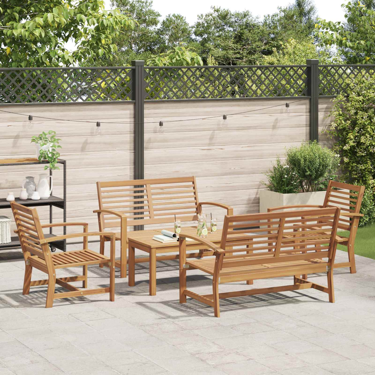 Gartenmöbelset aus Holz auf einer Terrasse. Enthält einen Tisch, Stühle und eine Bank. Der Hintergrund hat einen Zaun und Grün.