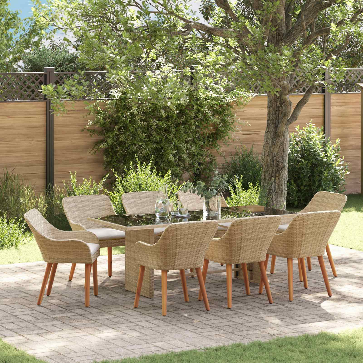 Juego de comedor al aire libre: mesa con tapa de cristal y 6 sillas de mimbre. Árboles y valla al fondo. Patio pavimentado.