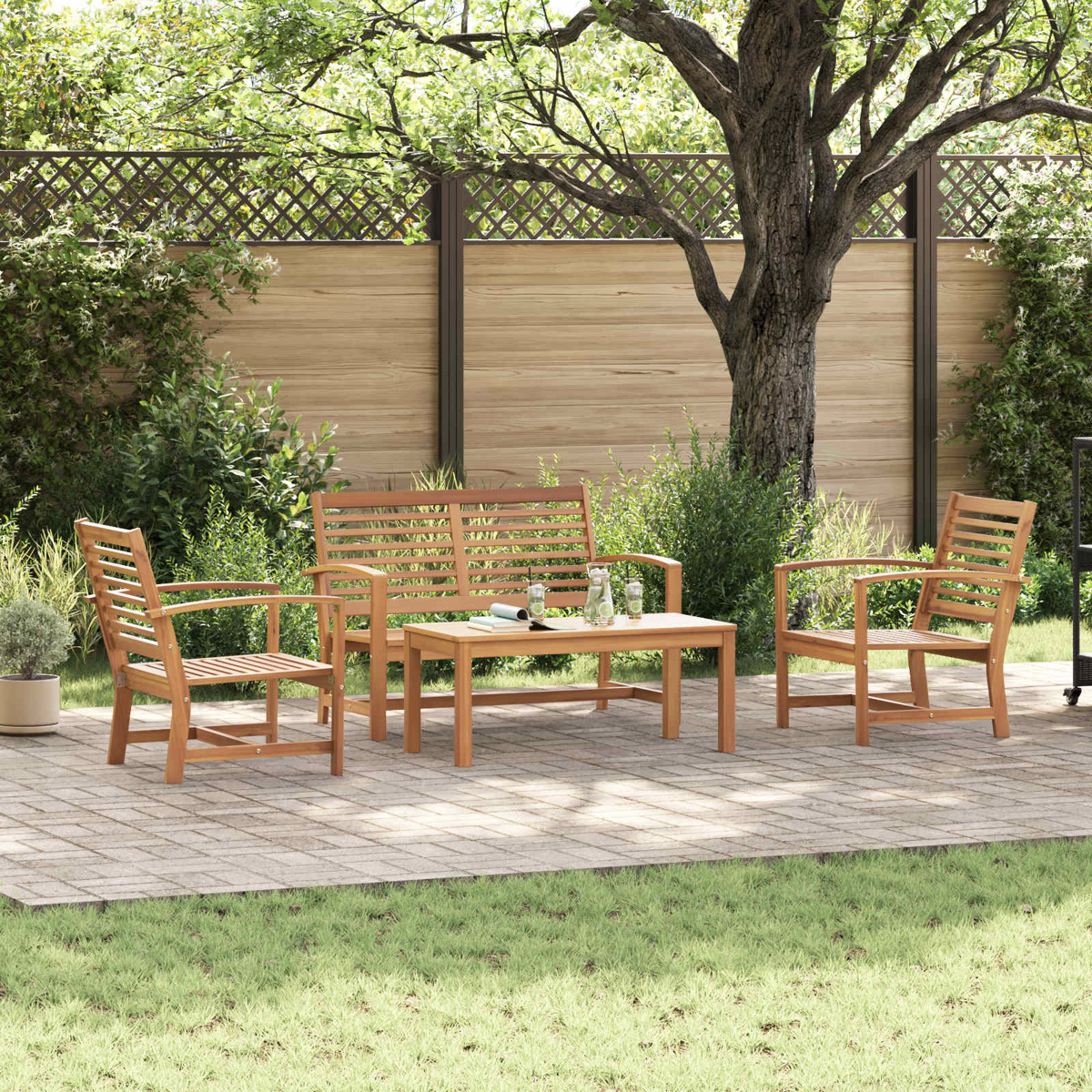 Holz-Gartenmöbel-Set auf einer Terrasse: zwei Stühle, eine Bank und ein Tisch. Im Hintergrund ein Zaun und Bäume.