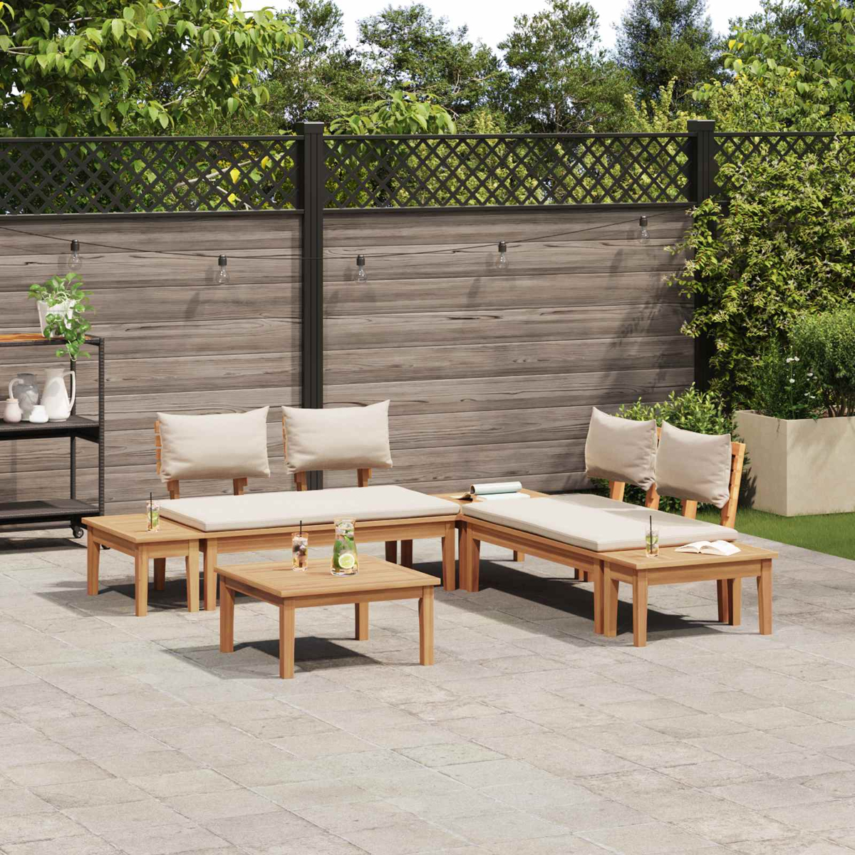 Terrassenmöbel-Set mit Holzmöbeln, beigen Kissen und Holzzaun. Getränke und Pflanzen sind auf den Tischen zu sehen.