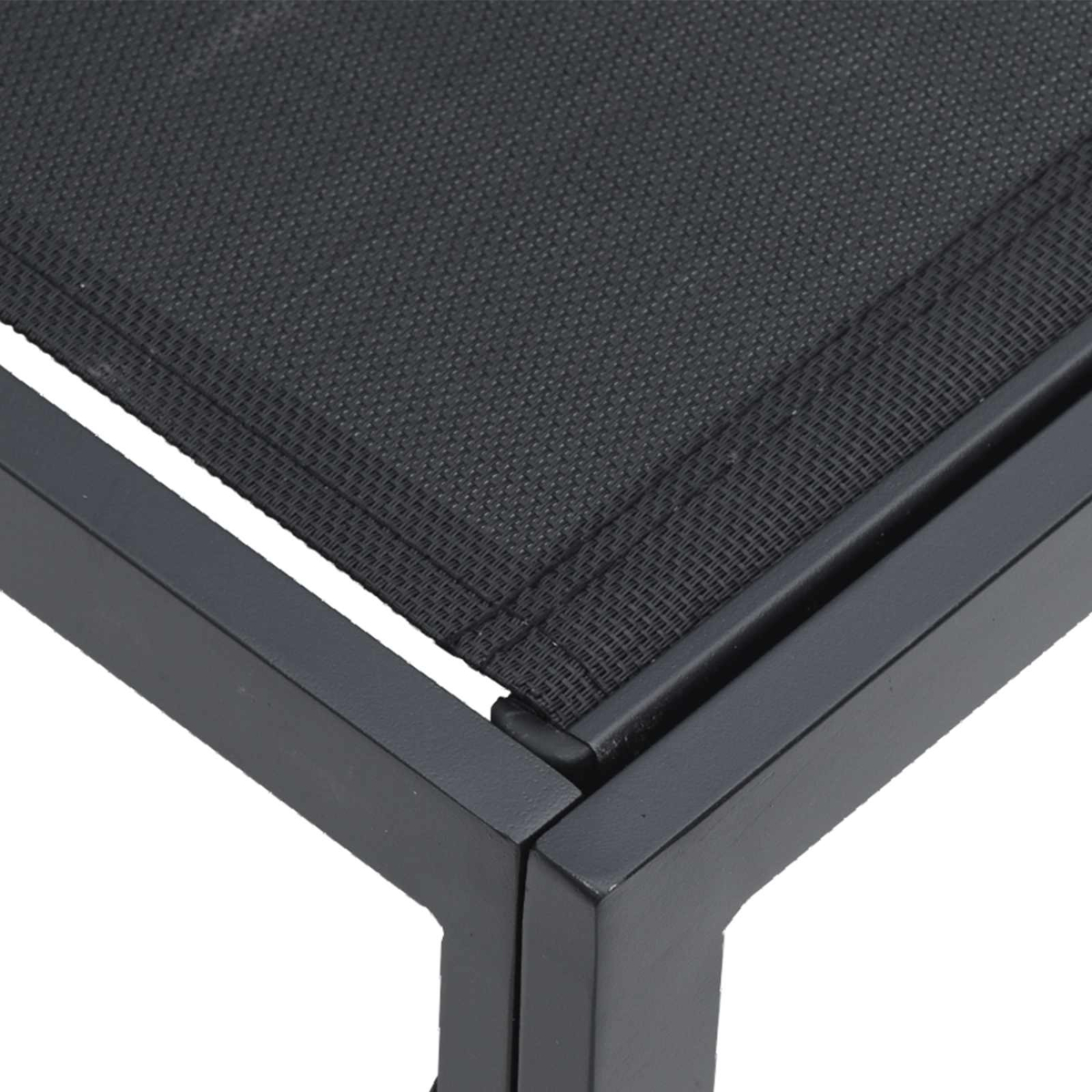 Primo piano di un tessuto a rete nero teso su un telaio in metallo grigio scuro, probabilmente un mobile.