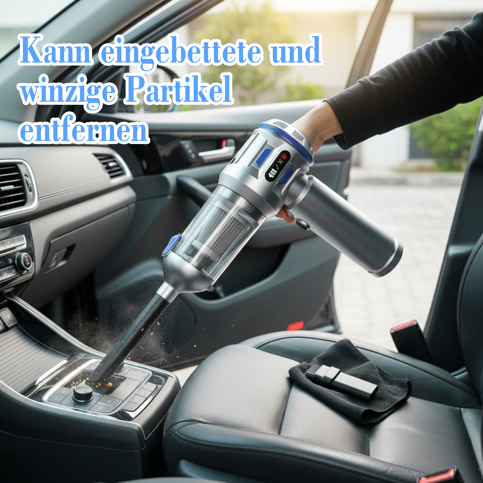 Eine Person saugt den Innenraum eines Autos mit einem Handstaubsauger. Der Staubsauger ist silber und blau. Staub ist sichtbar.