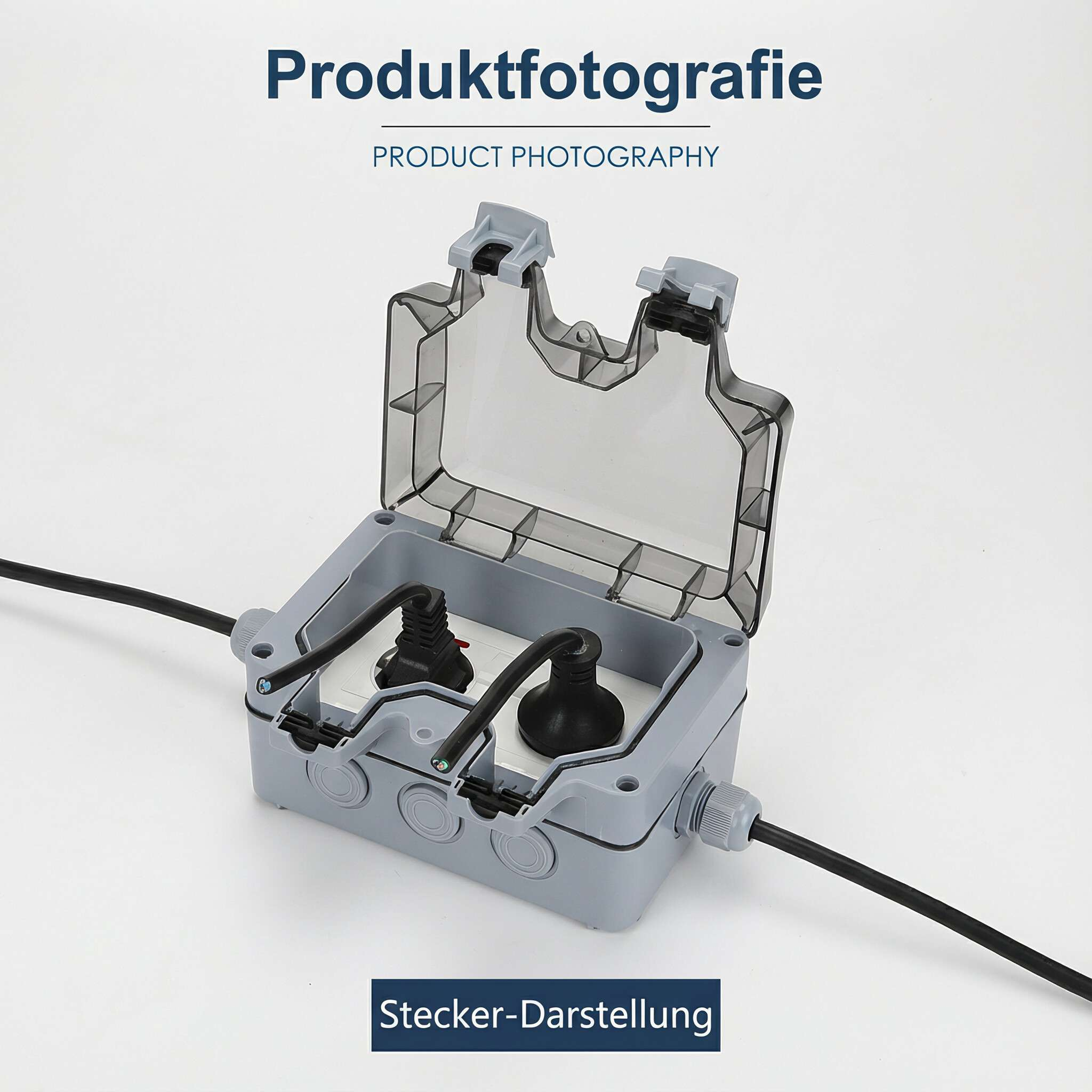 Graue Außensteckdose mit zwei Steckern. Schwarze Kabel sind angeschlossen. Produktfotografie.