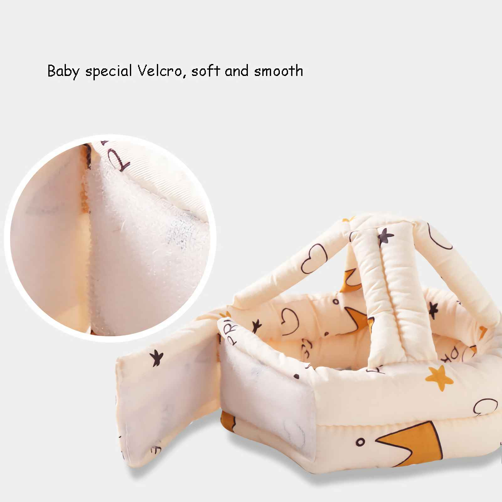 Cremefarbener Babyhelm mit Stern-, Herz- und Kronenmustern. Hat einen Klettverschluss. Der Hintergrund ist weiß.