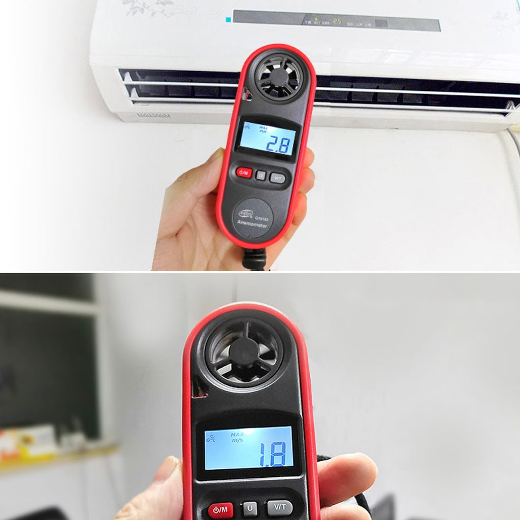 Eine Hand hält ein rot-schwarzes Anemometer. Das Gerät zeigt einen Wert von 2,8 an. Im Hintergrund befindet sich eine Klimaanlage.