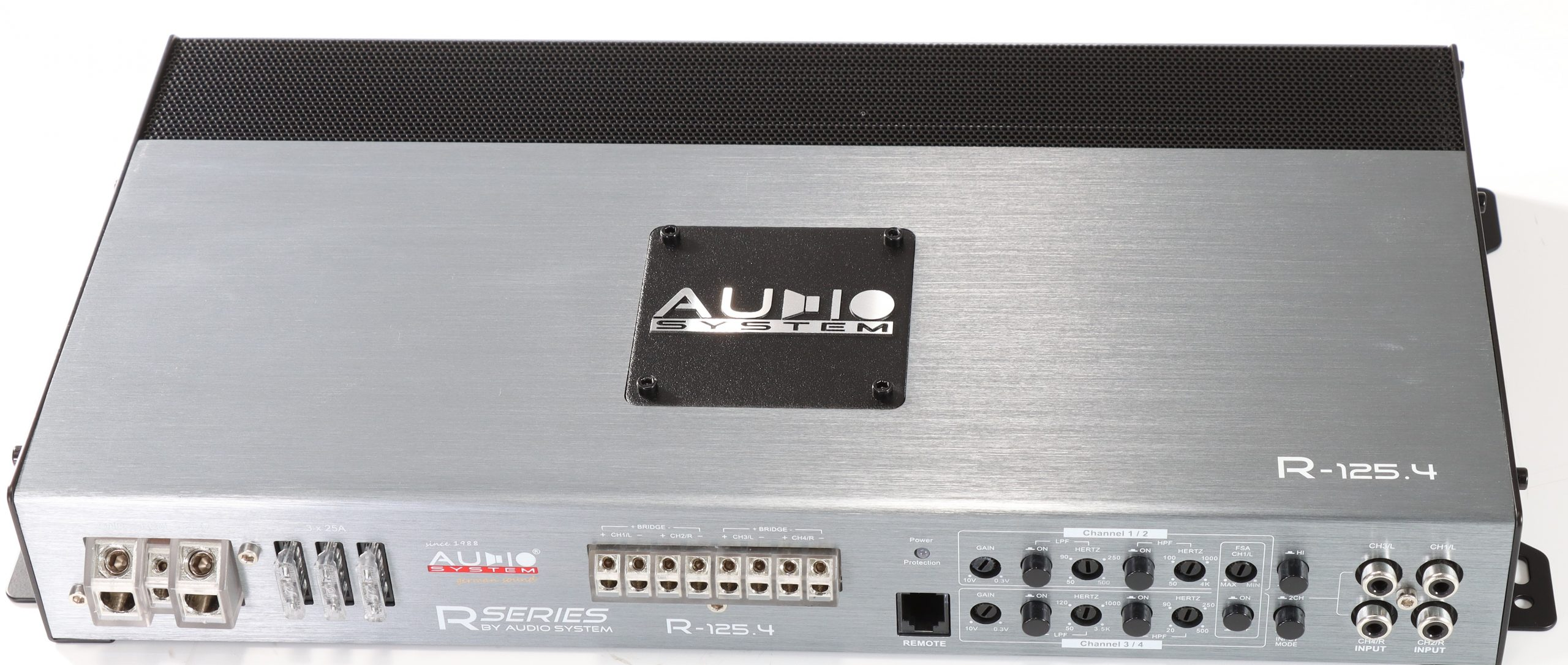Silberner Auto-Audioverstärker mit schwarzem Mesh-Top und Audio System-Logo. Bedienelemente und Eingangsanschlüsse sichtbar.