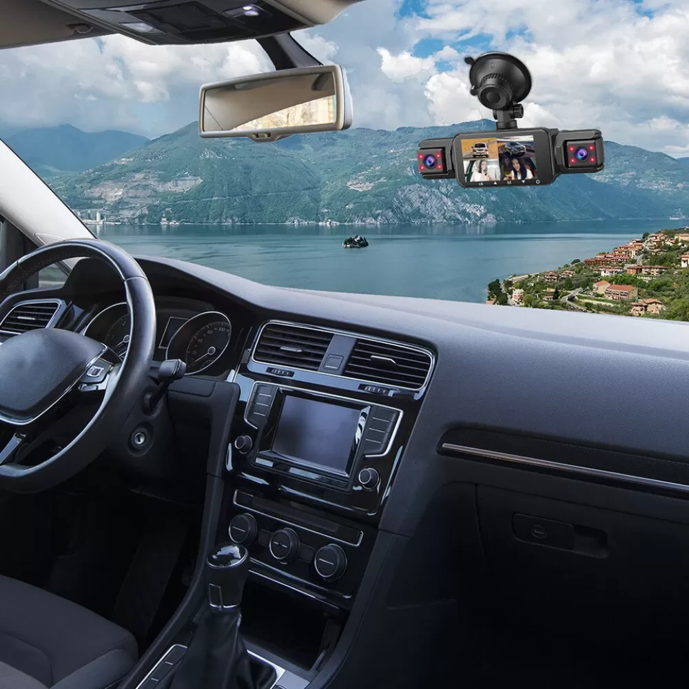 Autointerieur mit Armaturenbrett, Rückspiegel und Panoramablick auf Berge, See und Häuser. Klarer Himmel mit Wolken.
