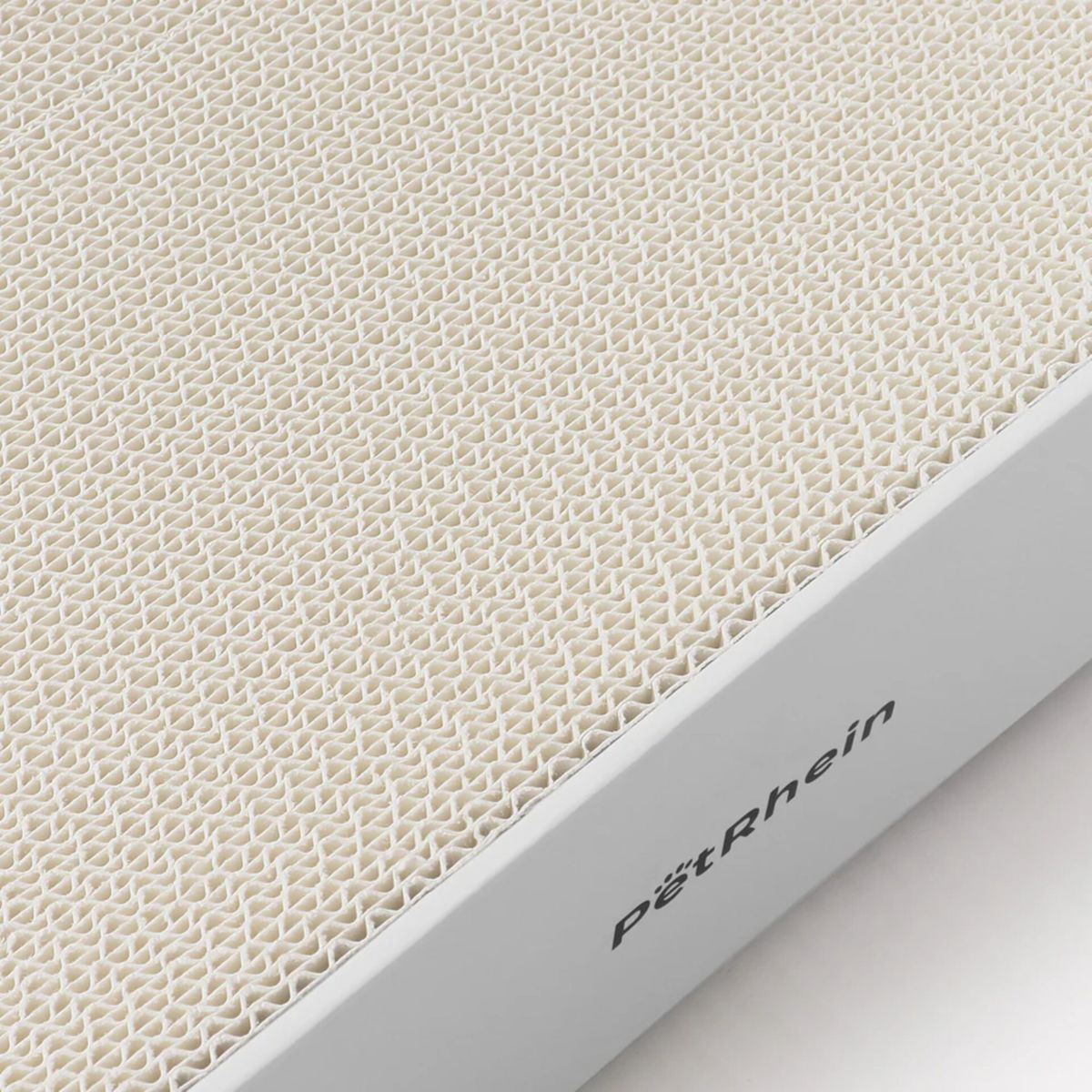 Primo piano di un tiragraffi per gatti. È un cartone bianco con una superficie ondulata beige. Il marchio 'Pöt Rhein' è visibile.