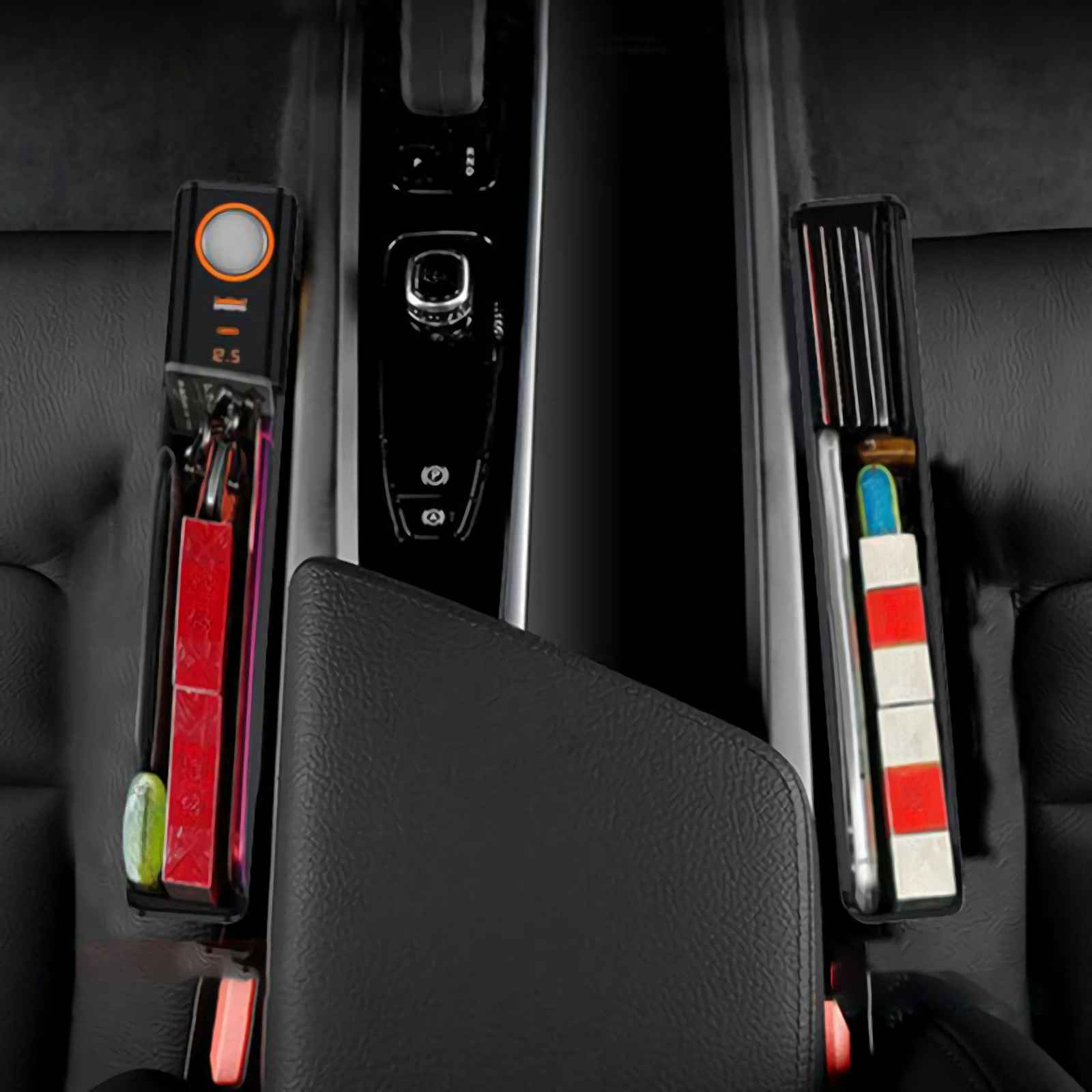 Autoinnenraum mit Ablagefächern. Eines enthält Schlüssel und rote Gegenstände, das andere ein Telefon und einen rot-weißen Gegenstand.