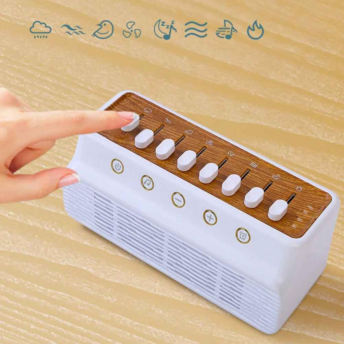 Eine weiße Geräuschmaschine mit Holzplatte, eine Hand berührt eine Taste. Verschiedene Symbole und Schieberegler sind sichtbar.