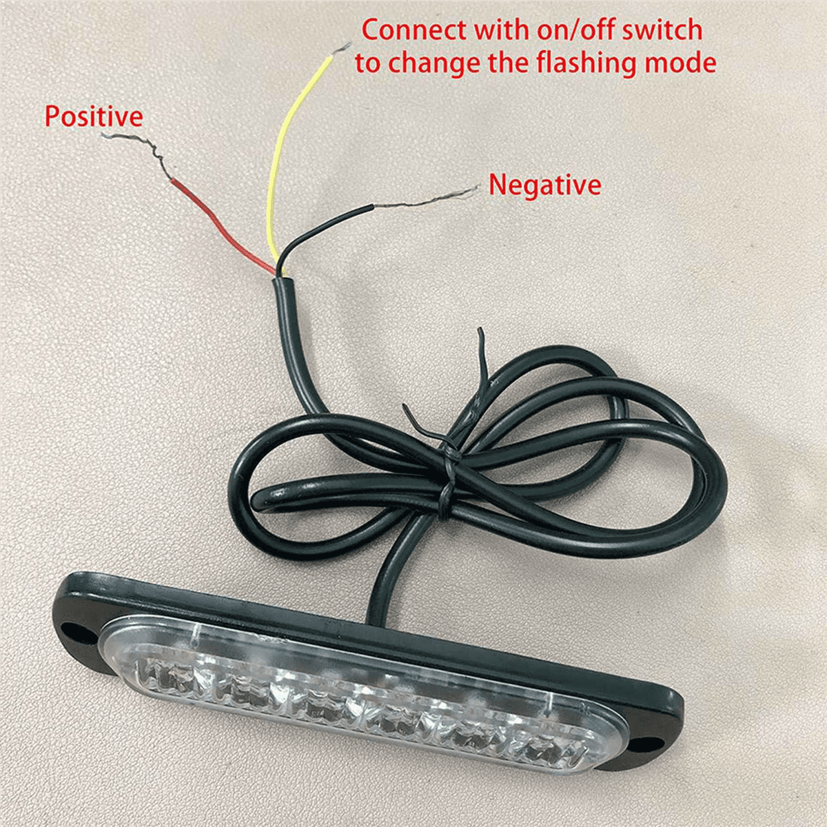 Ein schwarzer LED-Lichtbalken mit Drähten, die mit positiv und negativ beschriftet sind, und einem gelben Draht. Der Text sagt, dass er mit einem Ein/Aus-Schalter verbunden werden soll.