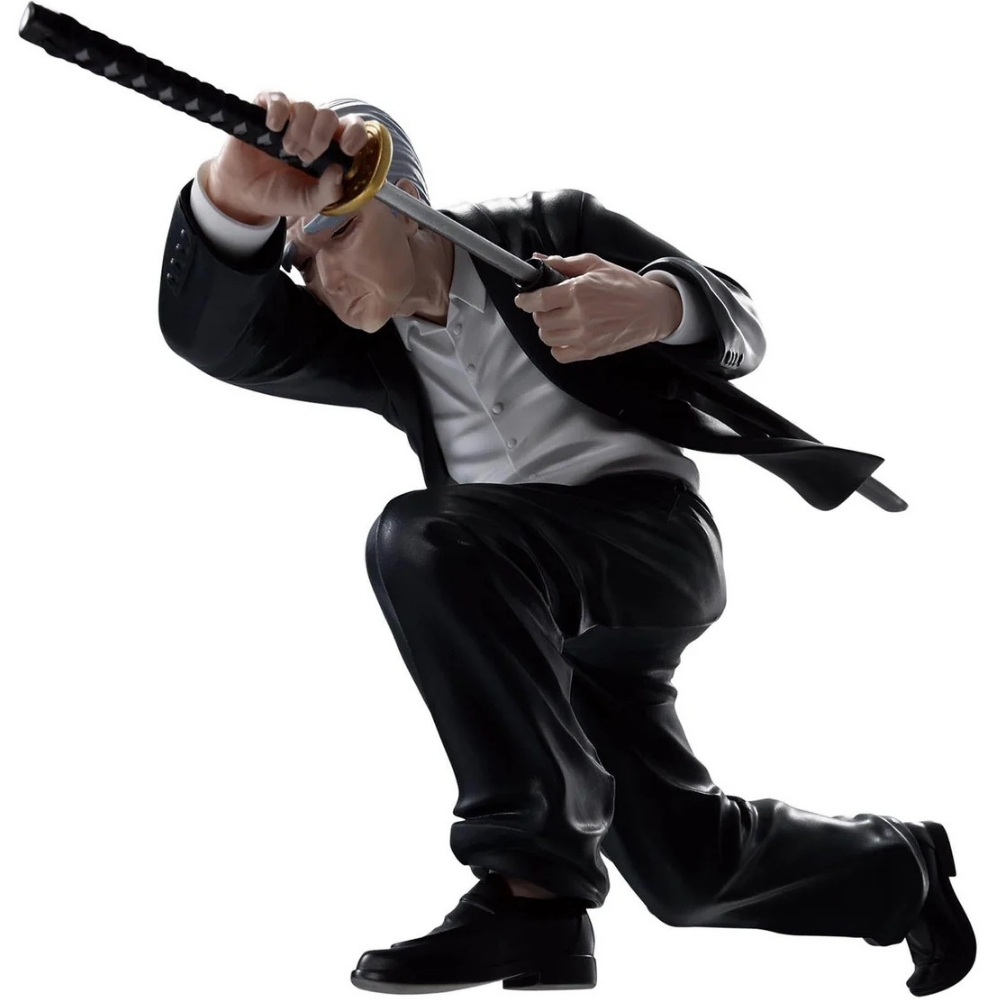 Un uomo in giacca e cravatta si inginocchia, tenendo una katana. La spada è sollevata come in un colpo. Lo sfondo è bianco.