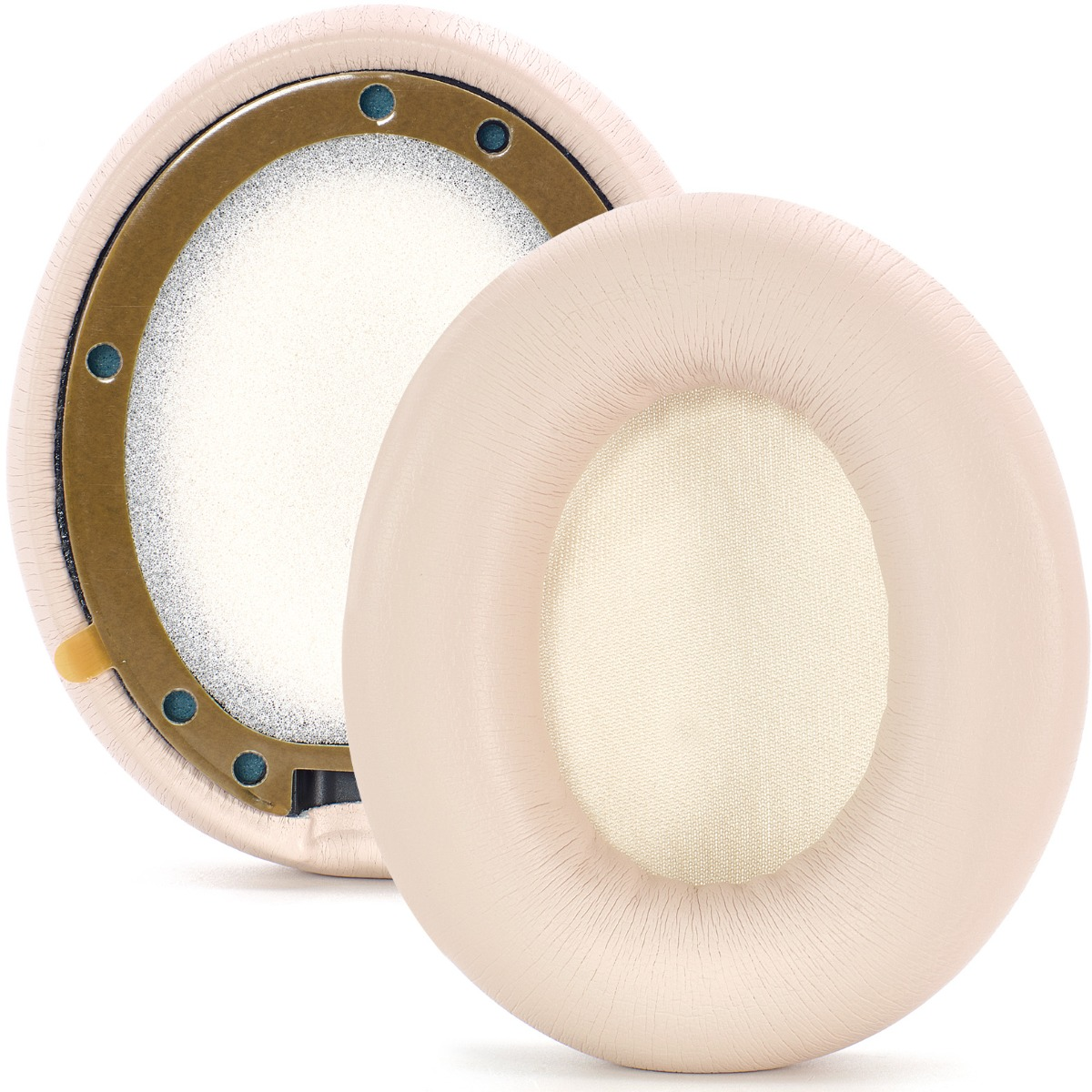 Dos almohadillas beige para auriculares. Una muestra los componentes internos, incluyendo una espuma blanca y un anillo dorado. La otra está entera.