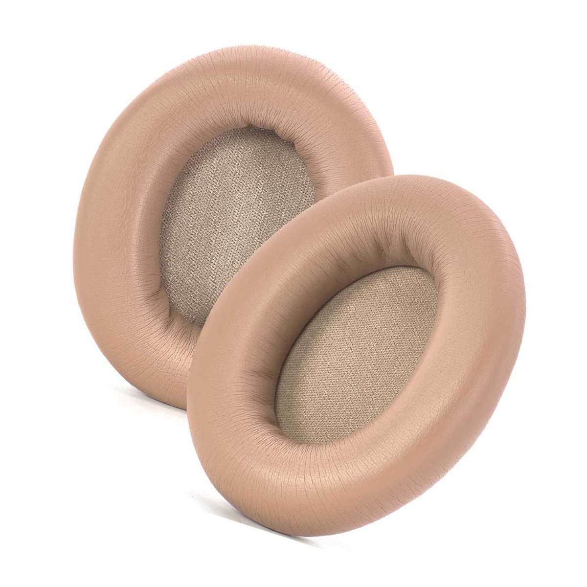 Dos almohadillas beige para auriculares. Son ovaladas, con un centro de tela texturizada y un exterior liso similar al cuero.