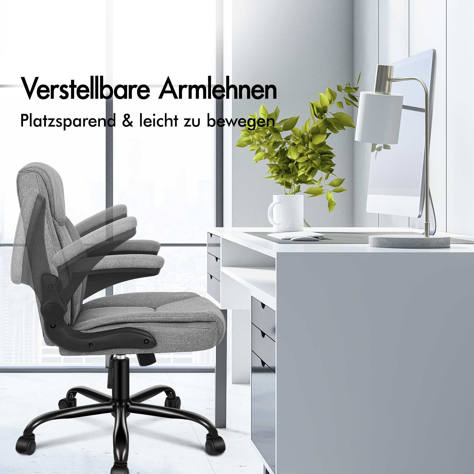 Silla de oficina con reposabrazos ajustables. La silla es gris. Escritorio, lámpara y vegetación en el fondo. Pared blanca.
