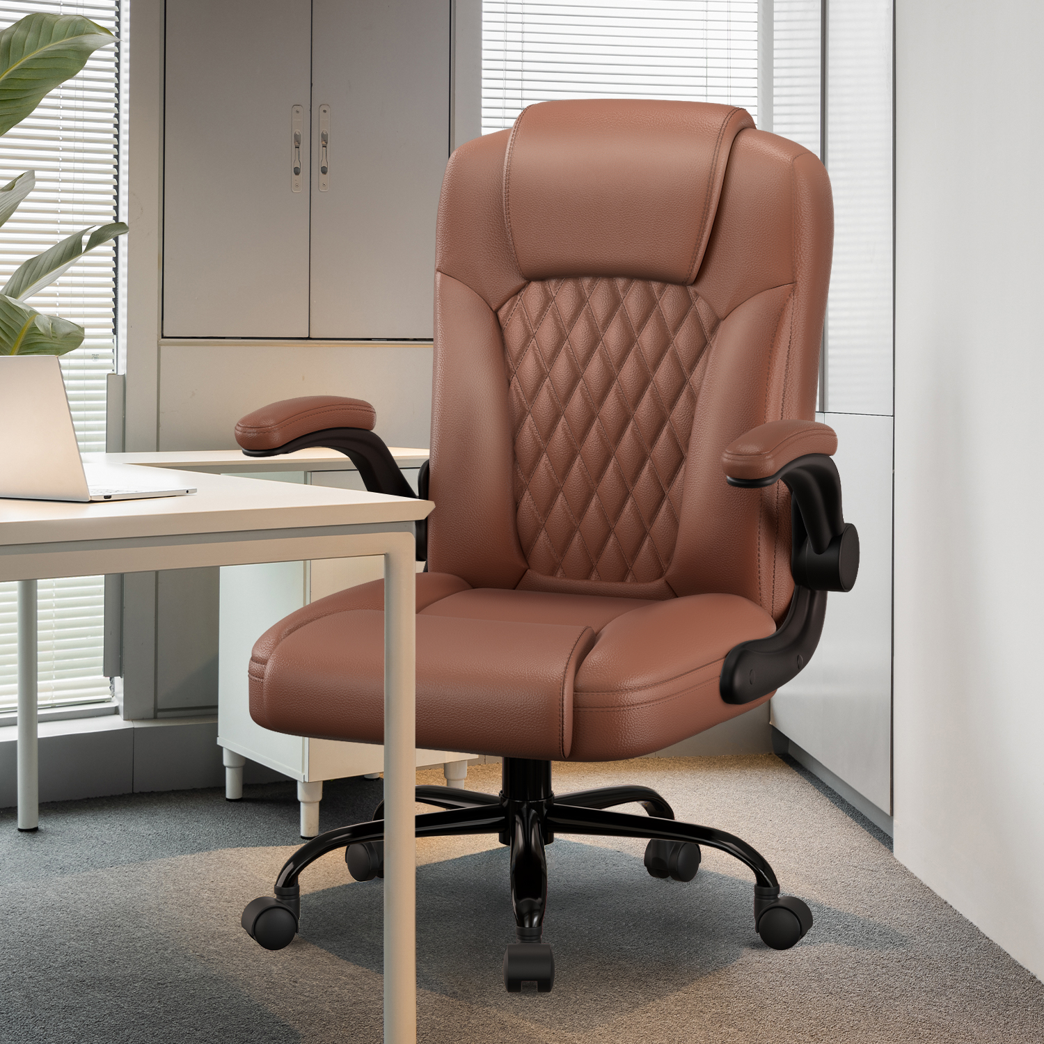 Ein brauner Bürostuhl aus Leder mit rautenförmigem Rückenteil, schwarzem Gestell und Armlehnen steht in einem modernen Büro. Ein Schreibtisch und ein Fenster sind sichtbar.