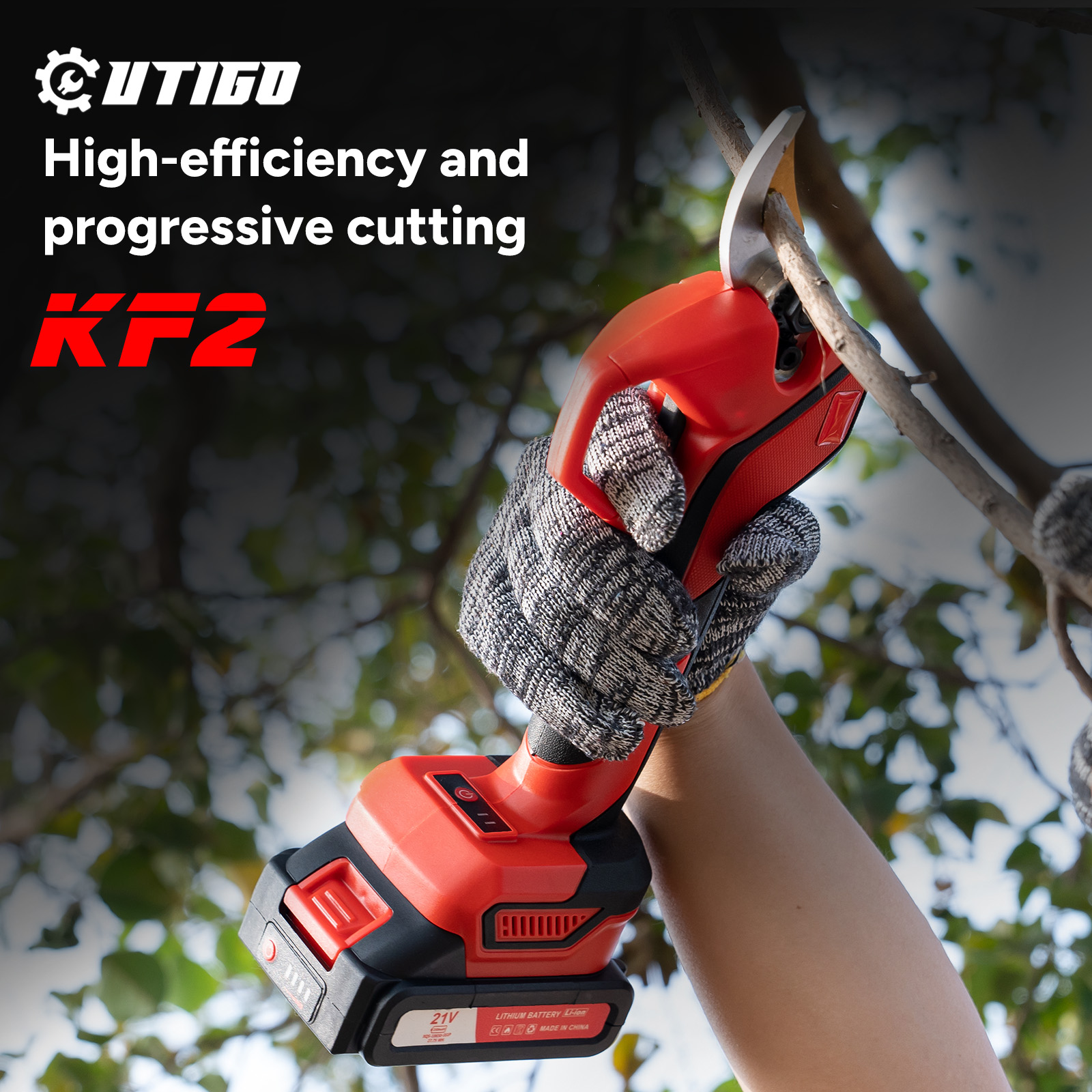 Osoba używa czerwono-czarnych elektrycznych nożyc do przycinania gałęzi drzewa. Osoba ma na sobie rękawicę.