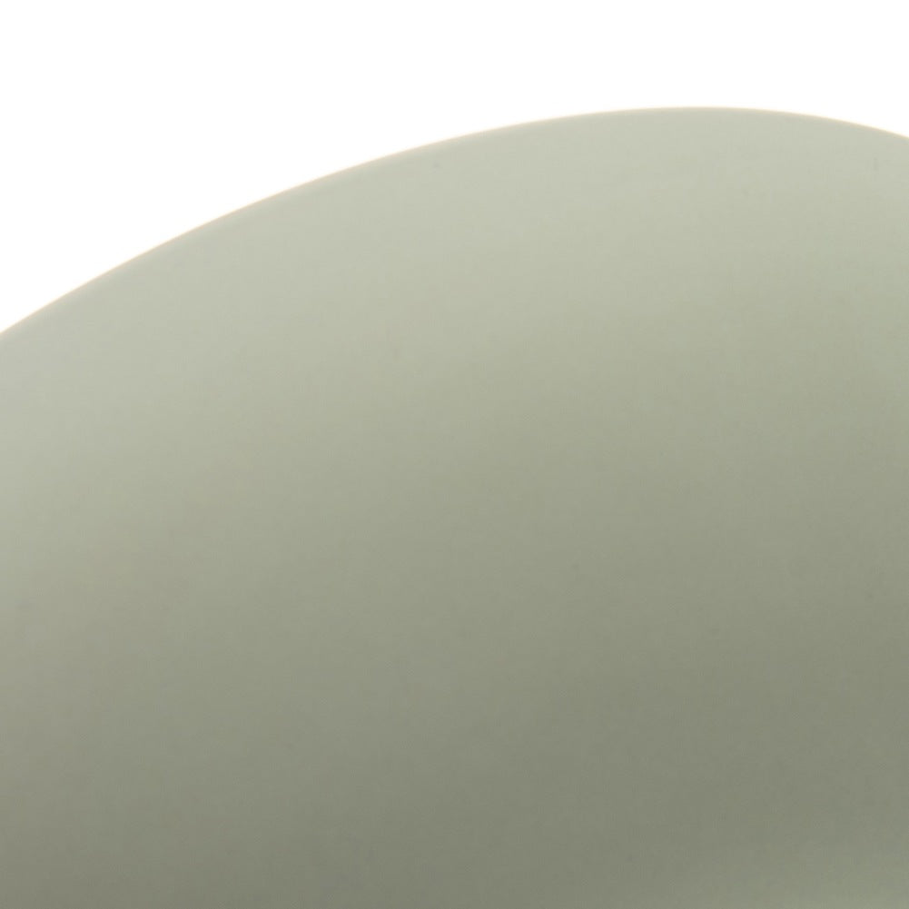 Primer plano de una superficie verde pálido con borde curvo sobre un fondo blanco.