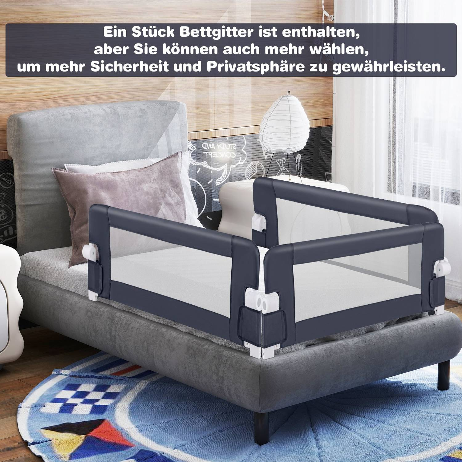 Una barandilla gris está sujeta a un sofá gris. Una alfombra azul con un dibujo está en el suelo. Hay almohadas y una lámpara en el fondo.