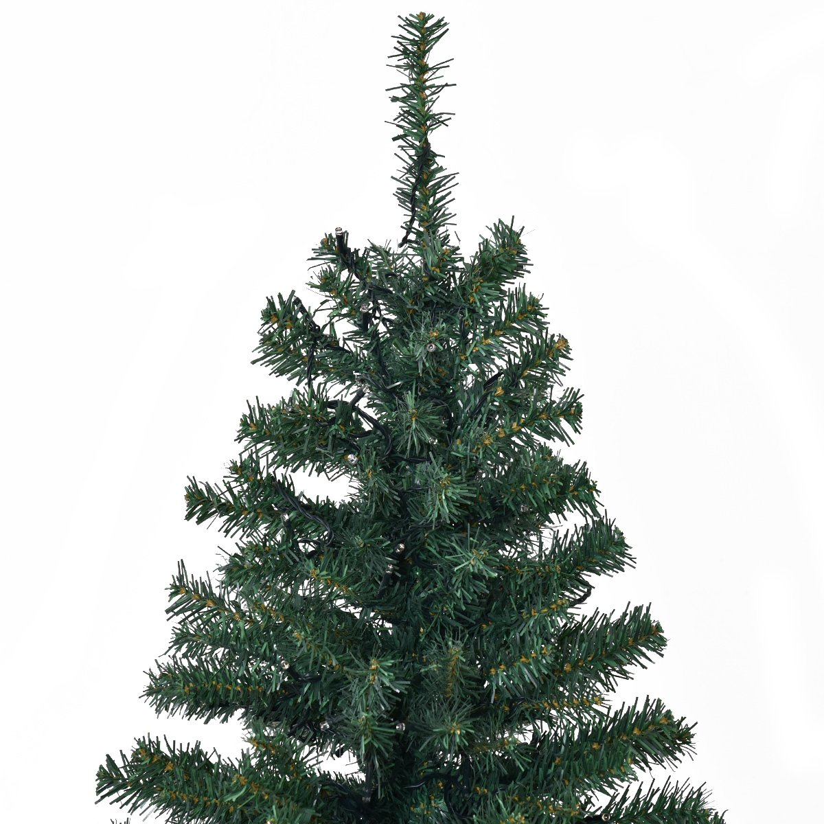 Primer plano de un árbol de Navidad artificial verde sobre un fondo blanco. El árbol tiene agujas y no está decorado.