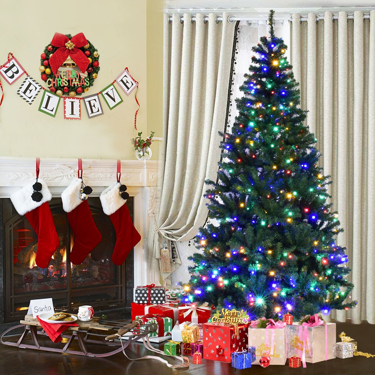 Un árbol de Navidad decorado con luces de colores. Regalos alrededor del árbol. Chimenea con calcetines y una pancarta de 'Believe' arriba.