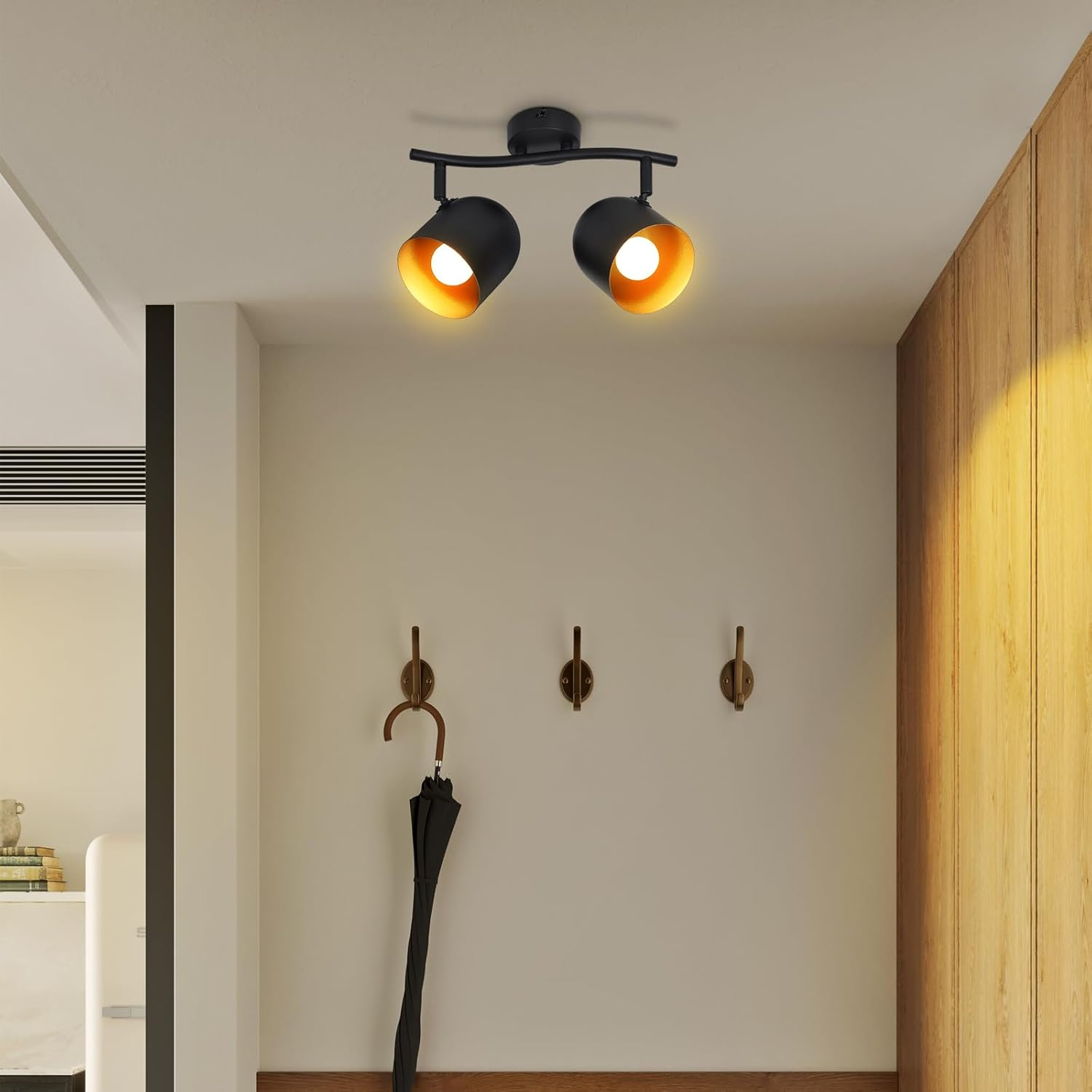 Un corridoio con plafoniera nera, dettagli in legno e un ombrello appeso a un gancio. La luce illumina la scena.