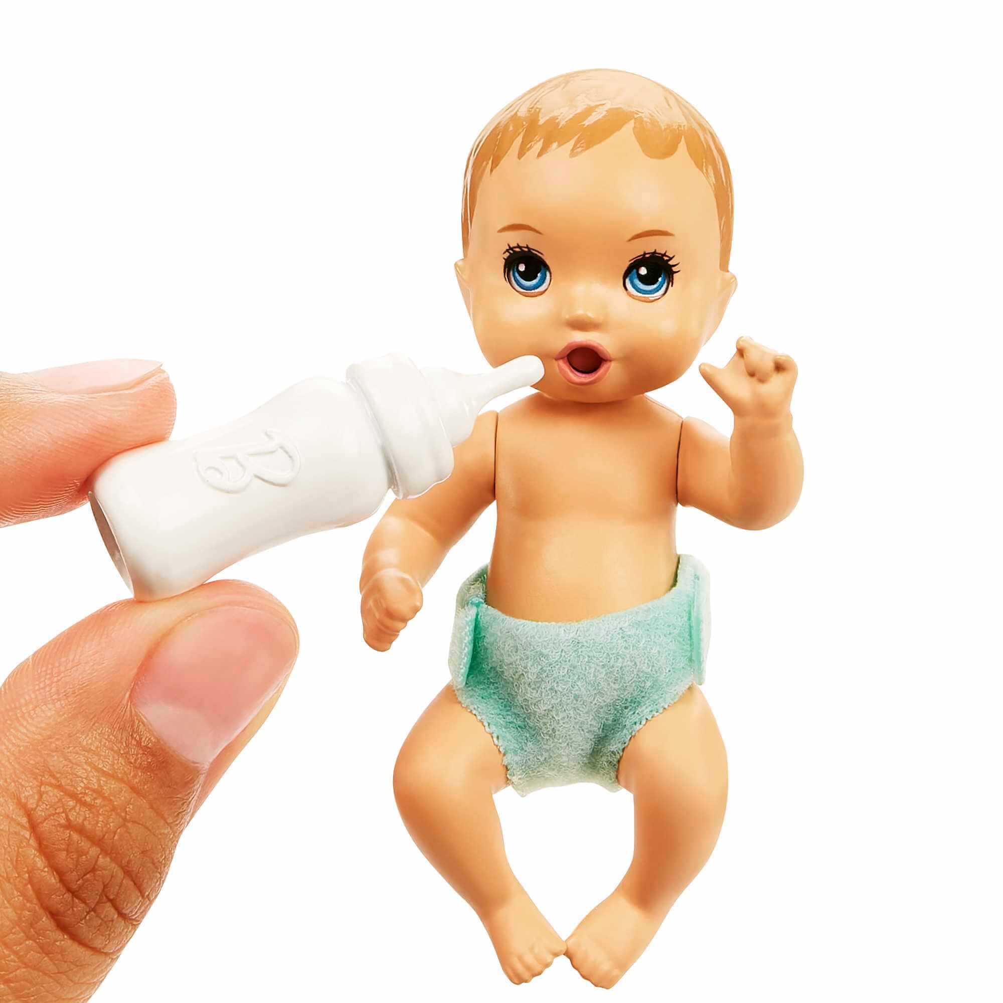 Eine Babypuppe mit blauen Augen und offenem Mund, die eine Windel trägt. Eine Hand hält eine Flasche an ihren Mund.