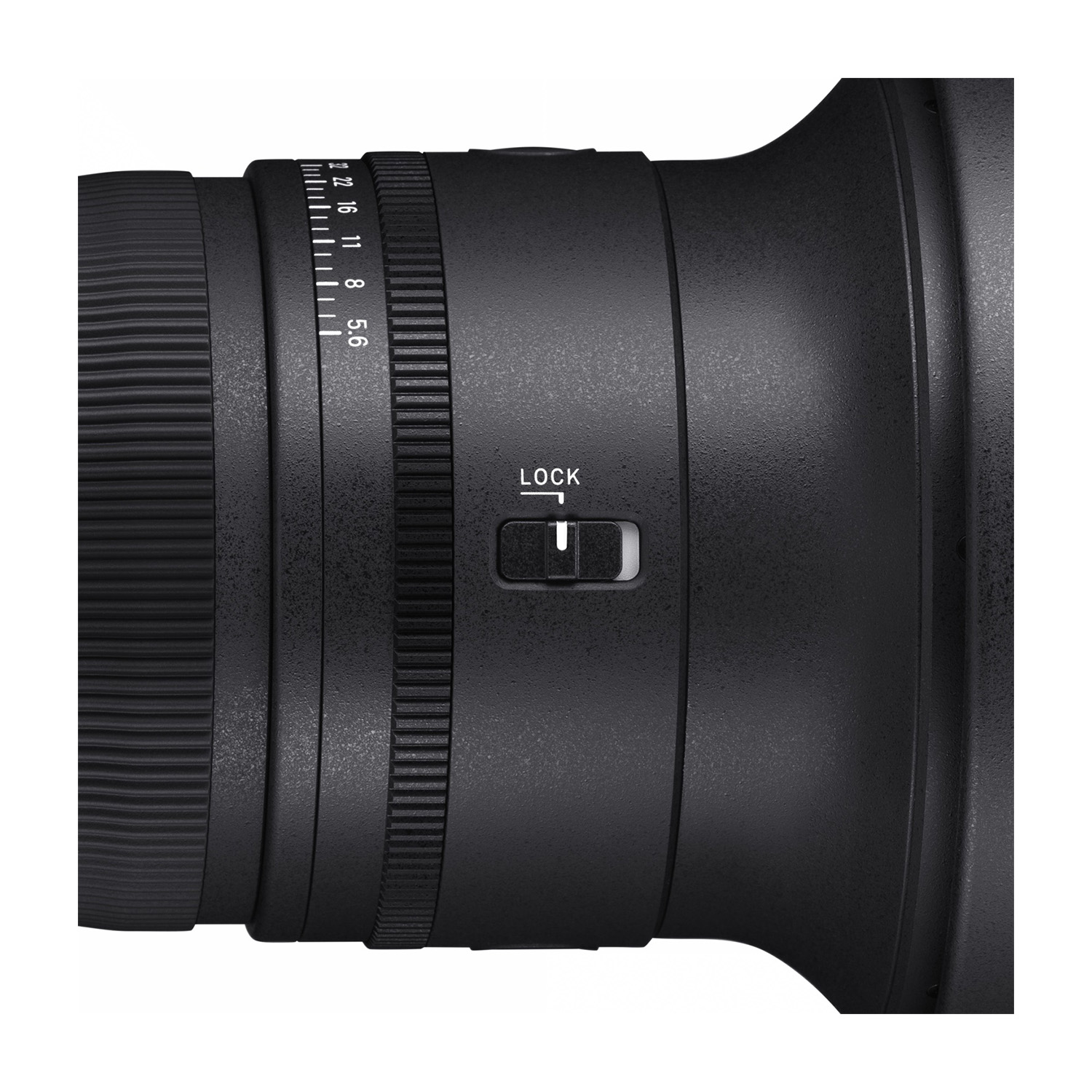 Zbliżenie czarnego obiektywu aparatu. Ma skalę ostrości i przełącznik blokady. Obiektyw jest cylindryczny z teksturowanymi powierzchniami.