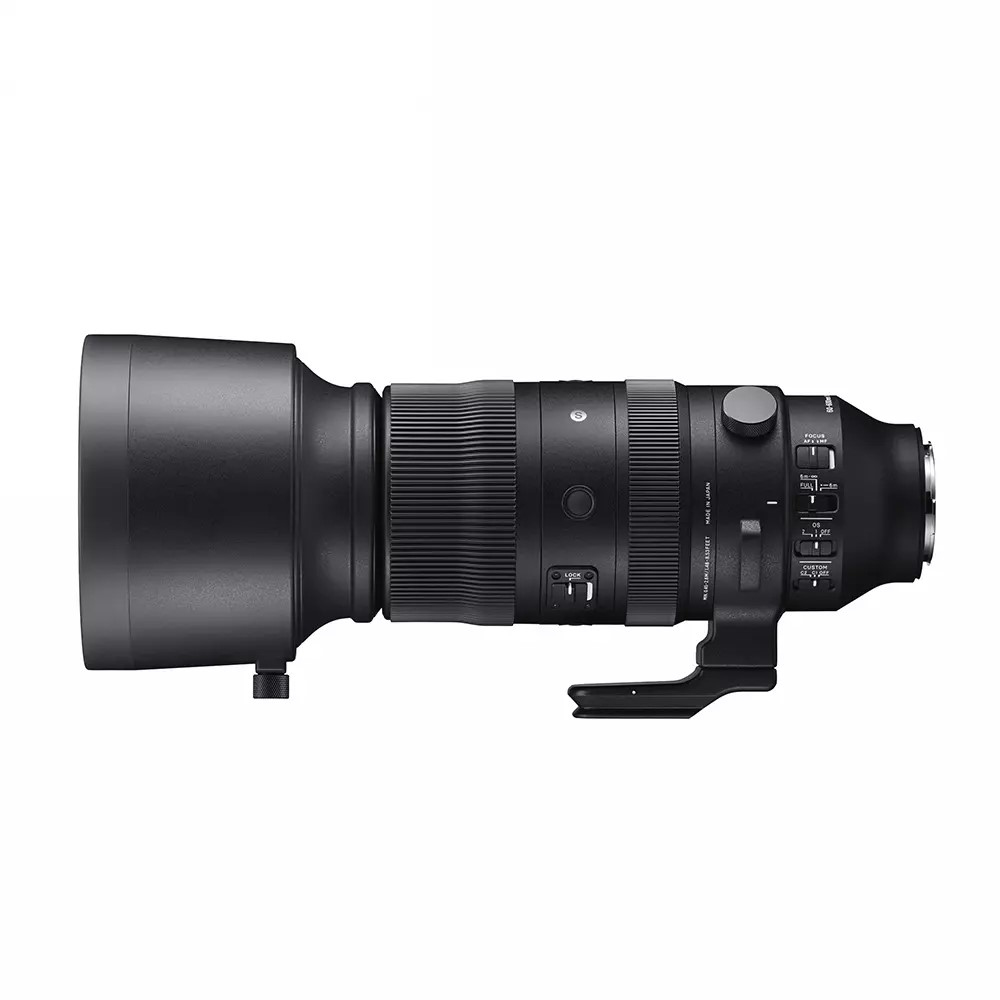 Un obiettivo per fotocamera Sigma nero su sfondo bianco. Ha varie manopole e impostazioni. L'obiettivo è cilindrico con un paraluce.