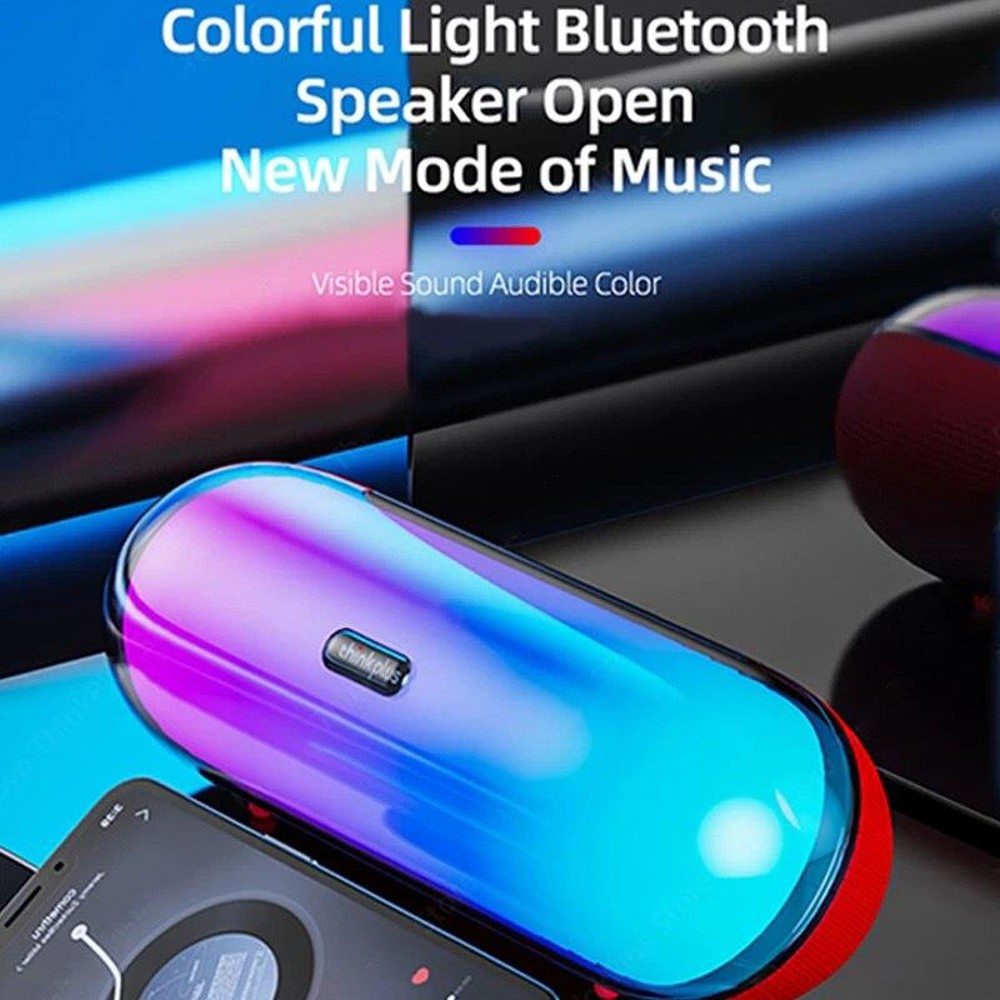 Mavi-mor geçişli renkli bir Bluetooth hoparlör bir telefonun üzerinde duruyor. Üstte 'Speaker Open New Mode of Music' yazıyor.