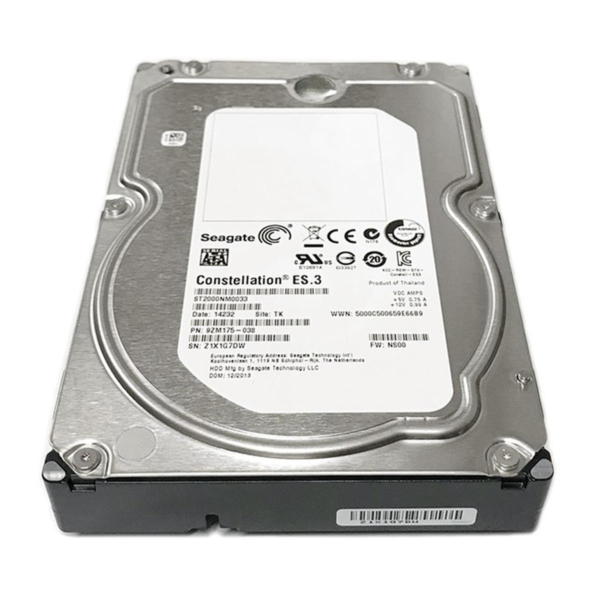 Un disco rigido Seagate Constellation ES.3 su una superficie bianca. Ha un coperchio metallico e una base nera, con etichette e loghi.