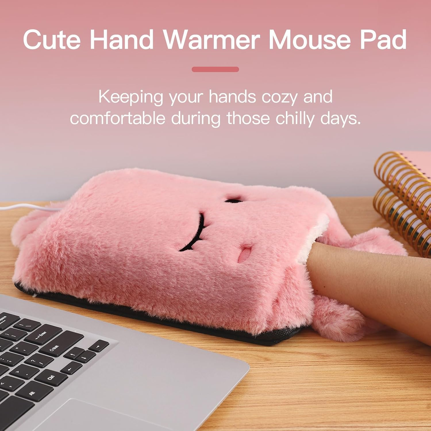 Ein rosa Handwärmer-Mauspad mit einer Hand darin. Daneben stehen ein Laptop und ein Notizbuch. Der Text lautet 'Cute Hand Warmer Mouse Pad'.