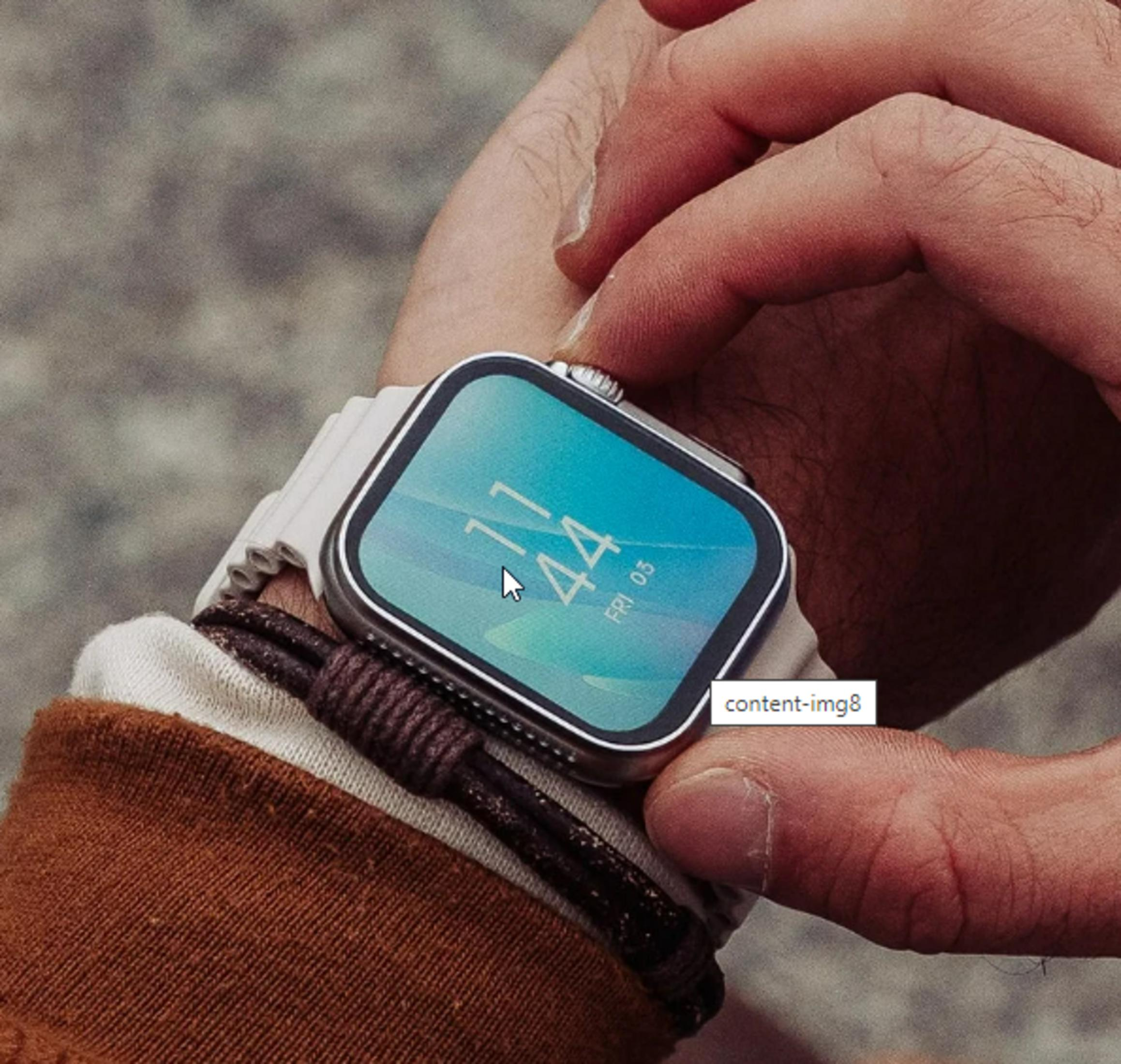 Dłoń osoby noszącej smartwatch. Zegarek pokazuje godzinę 11:44. Tło jest rozmyte.